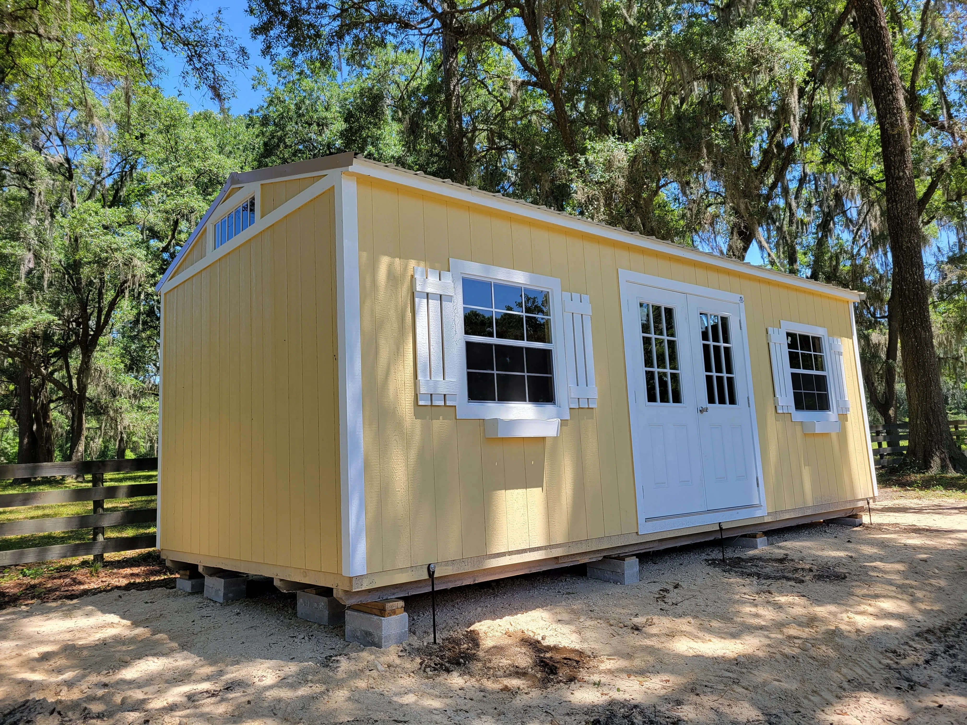 Yellow Urban shed with double doors and windows with shutters