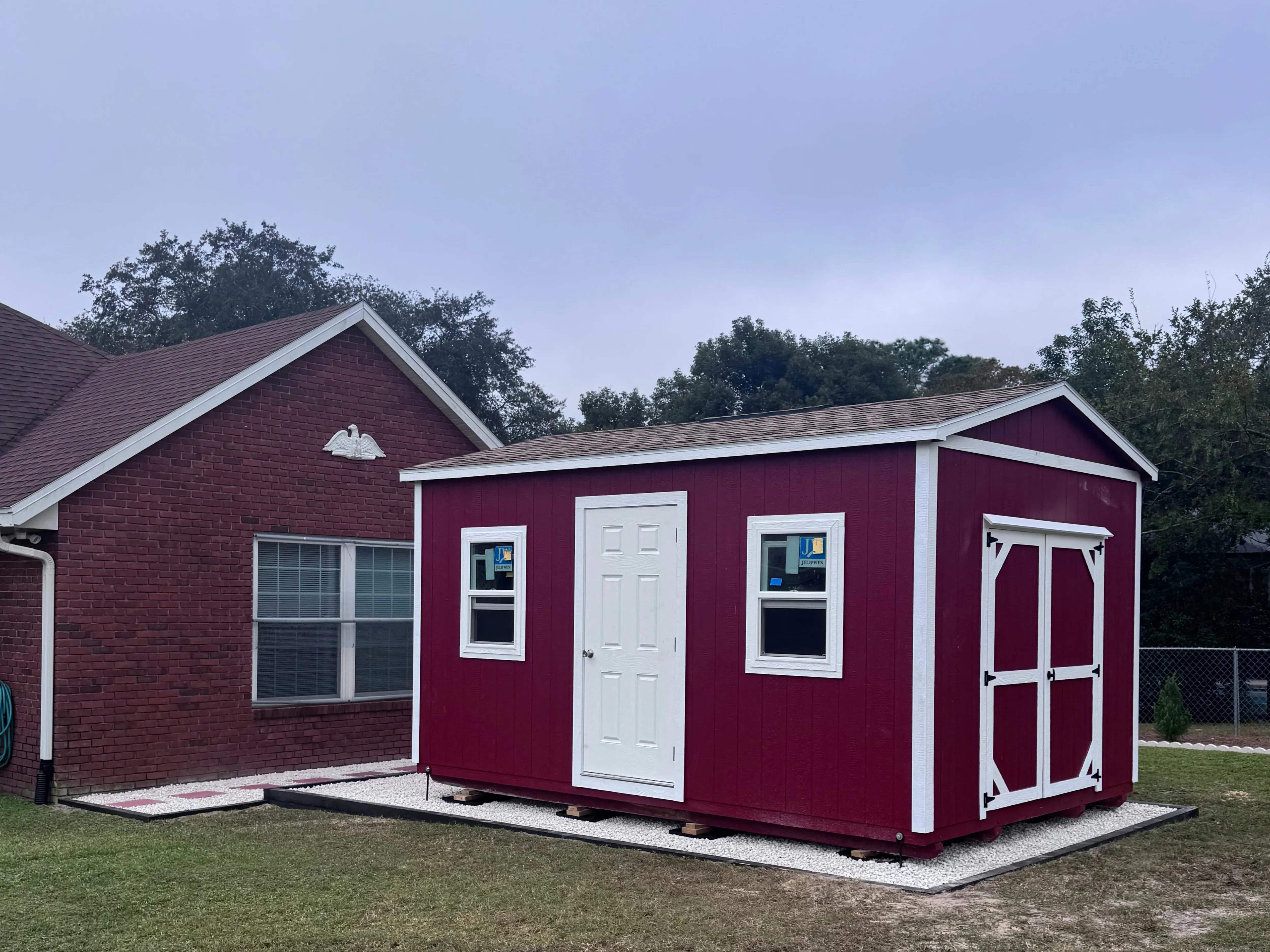 Red Garden Shed by brick house
