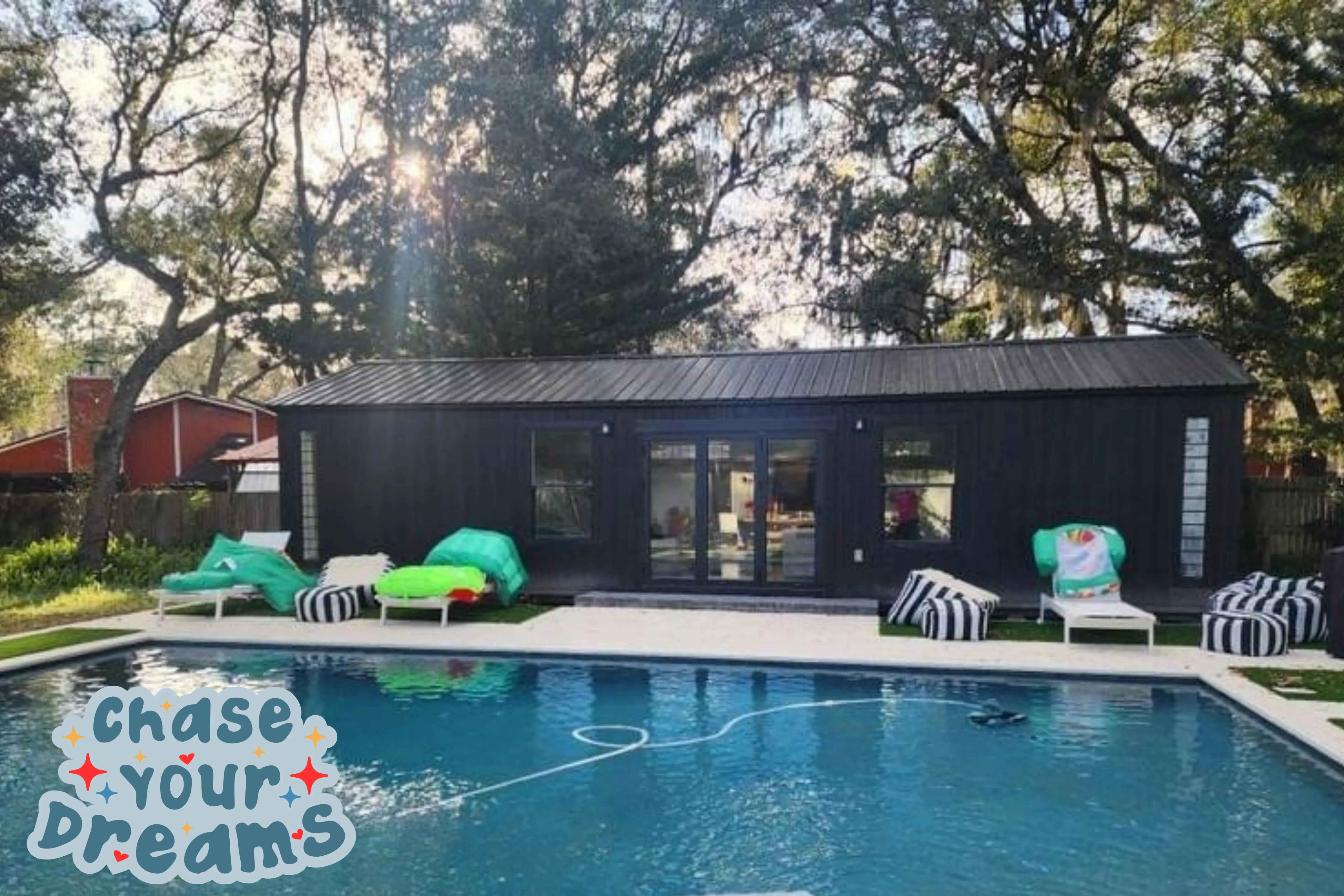 Cool black shed by a pool with glass patio doors and custom windows