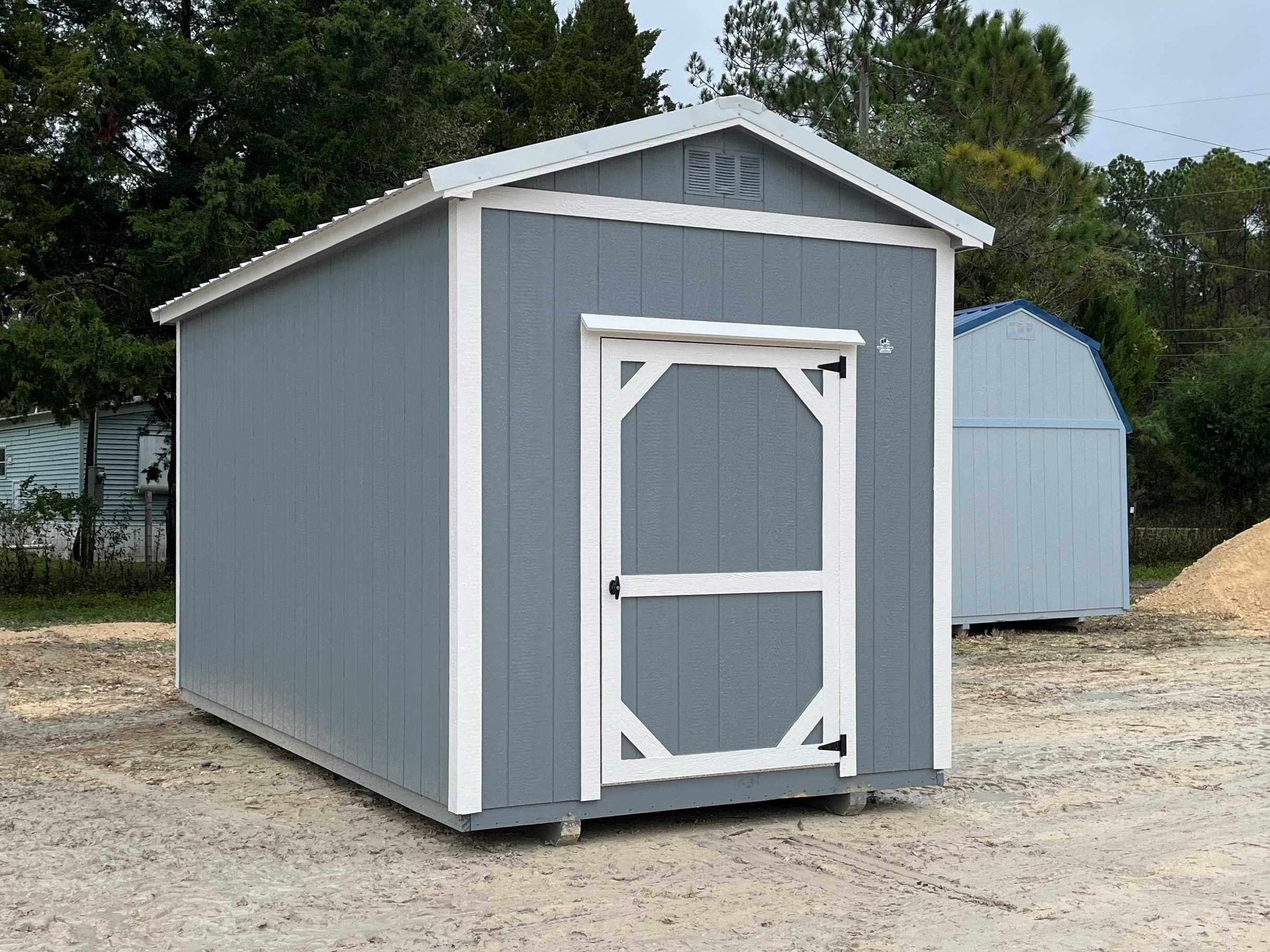 Exterior of a dark grey garden shed with a single wood door