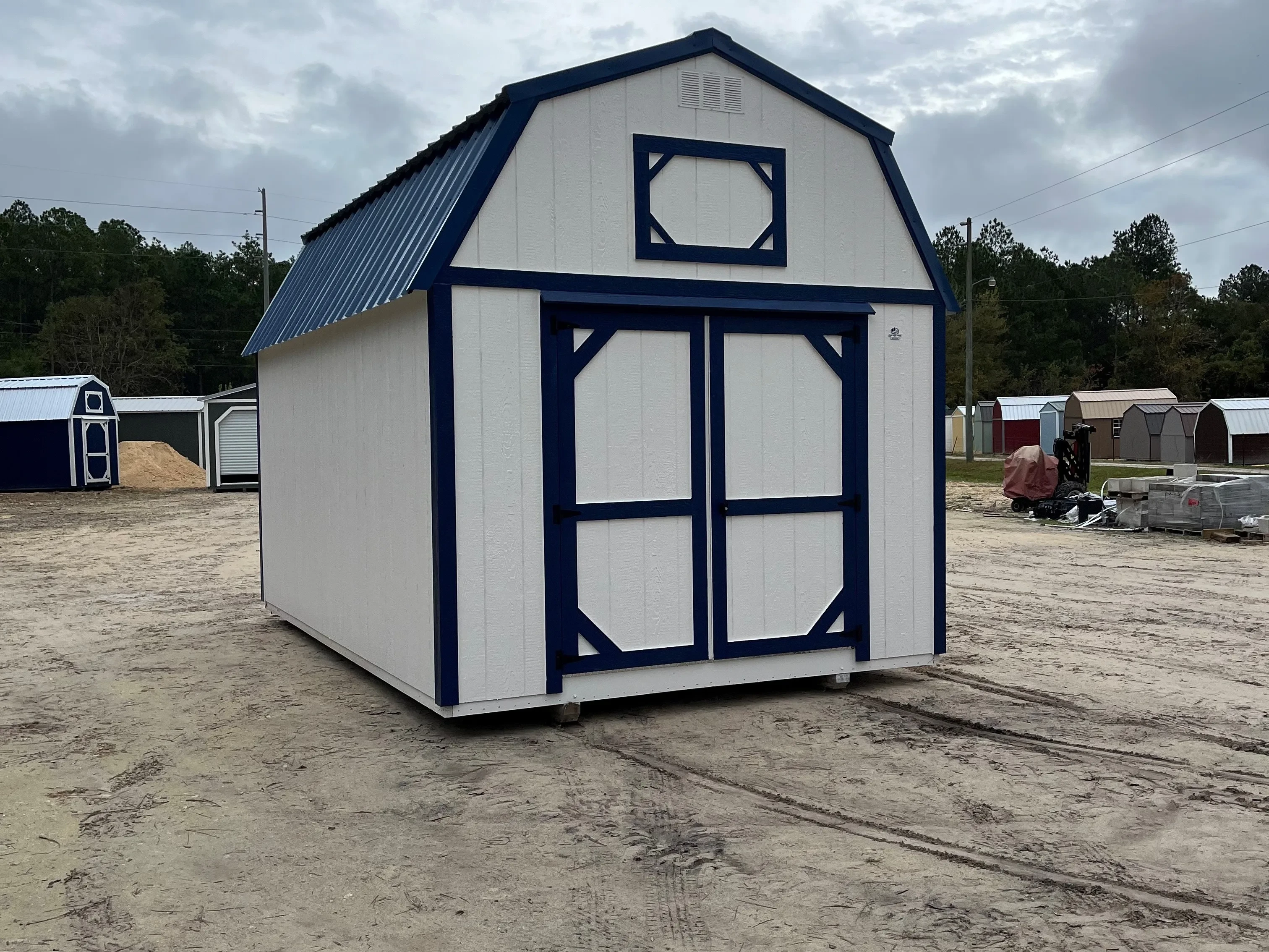 Exterior of a white 10x16 lofted barn with double wood doors