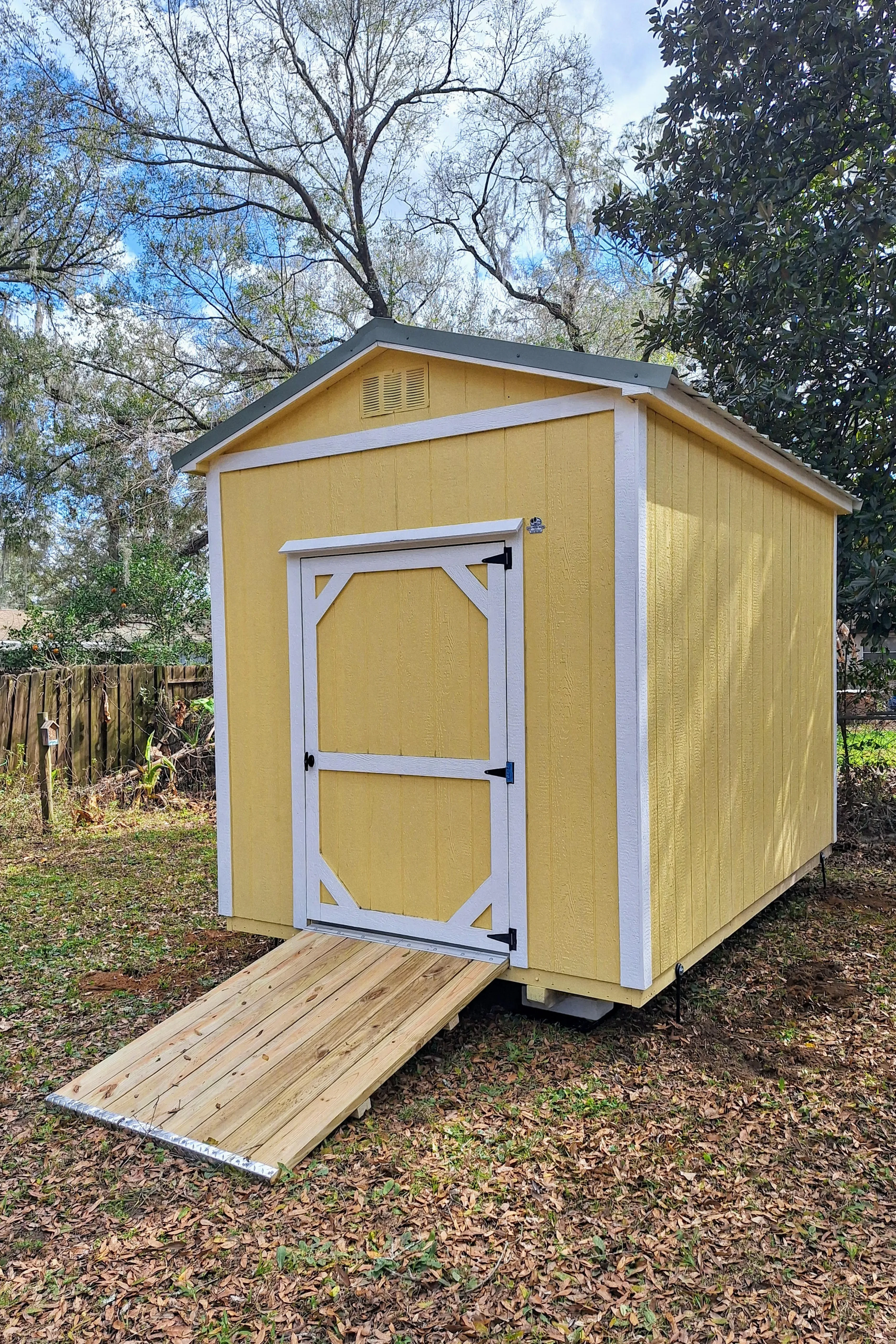 Sunshine yellow shed with a ramp for storage