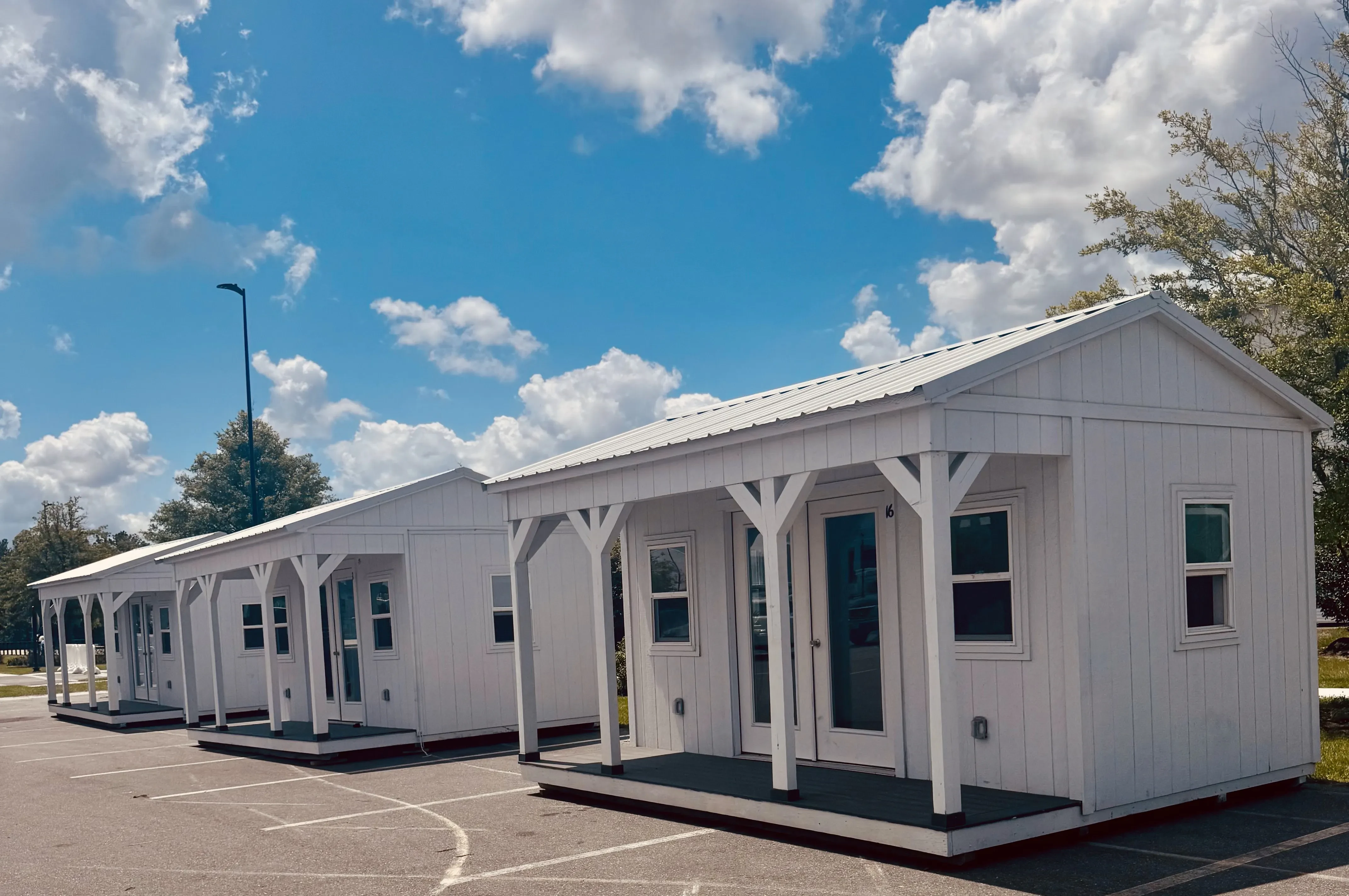 Row of white cabins with side porches with poly decking