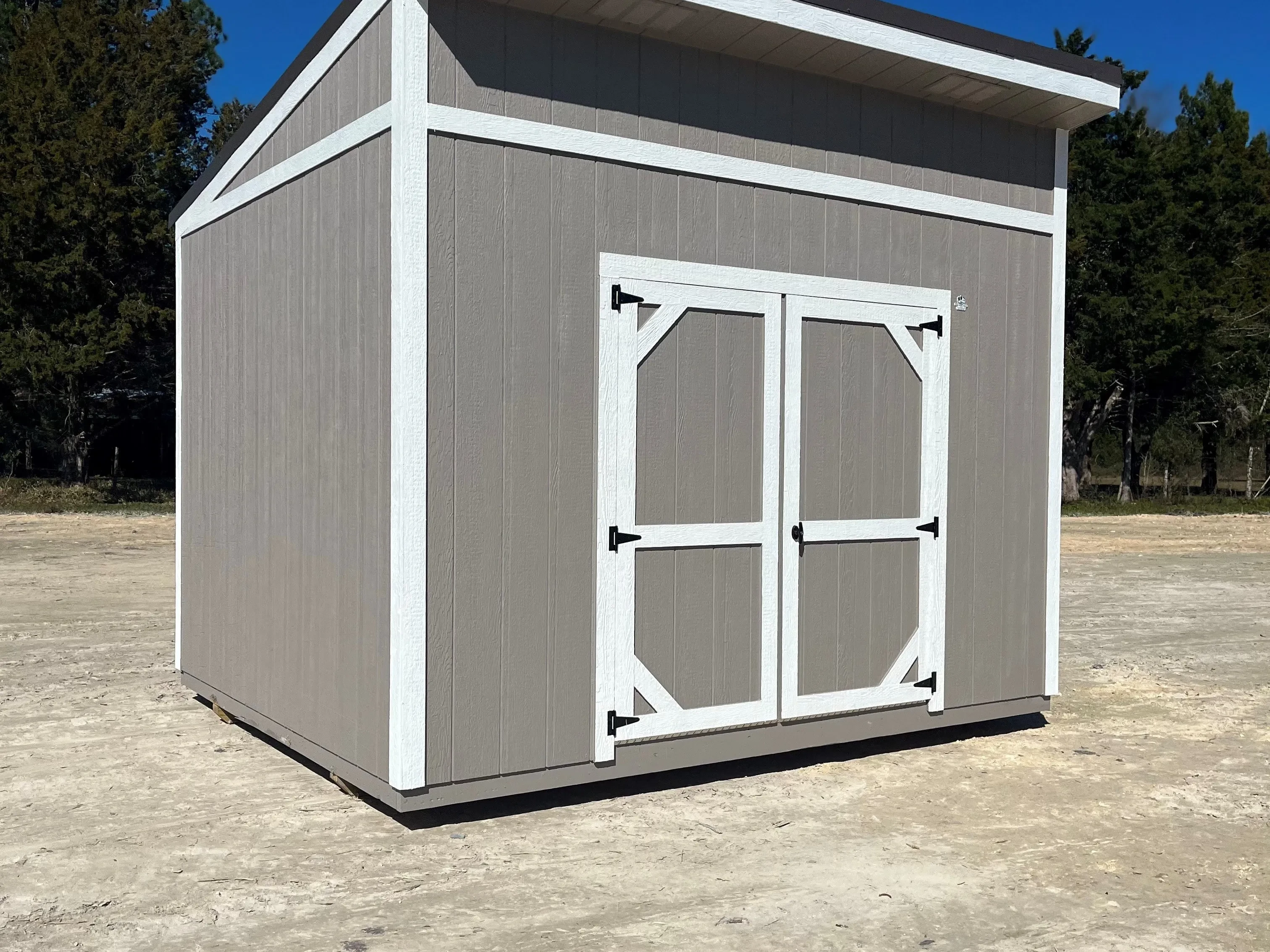 Exterior of a taupe with white trim 10x12 urban shed that has a double wood door