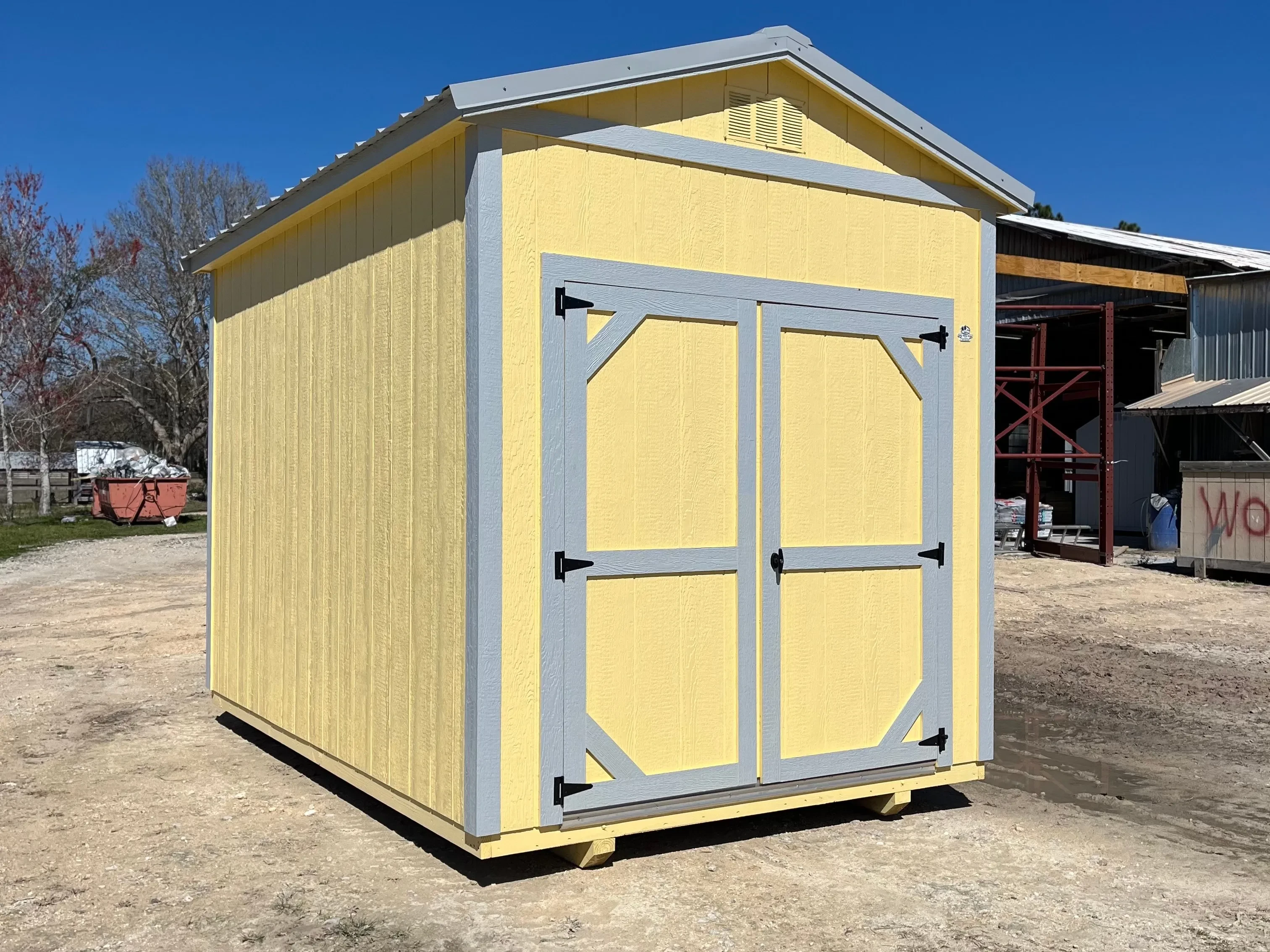 Exterior of an 8x12 yellow garden shed with double wood doors