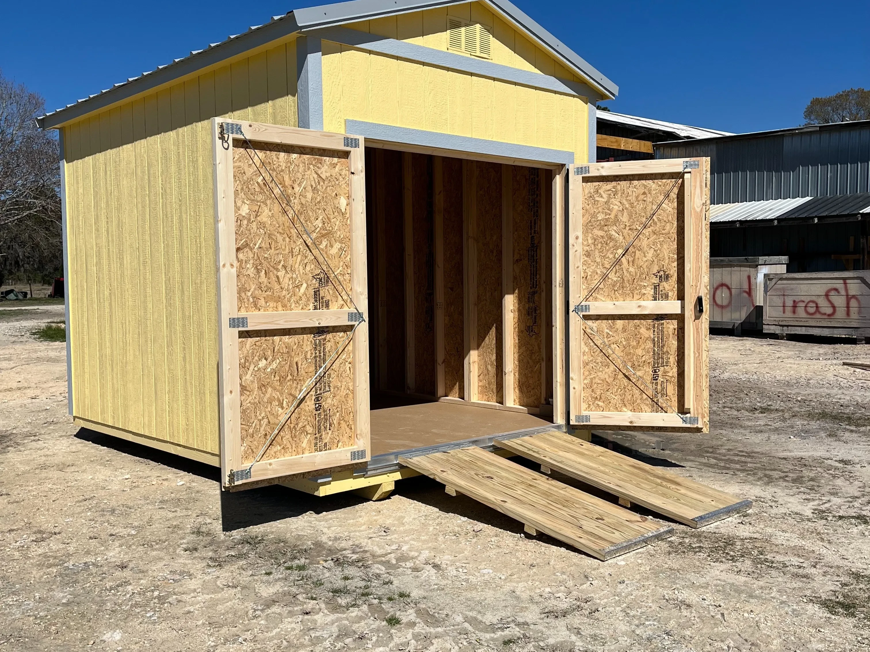 Exterior side of an 8x12 garden shed with doors open and ramps