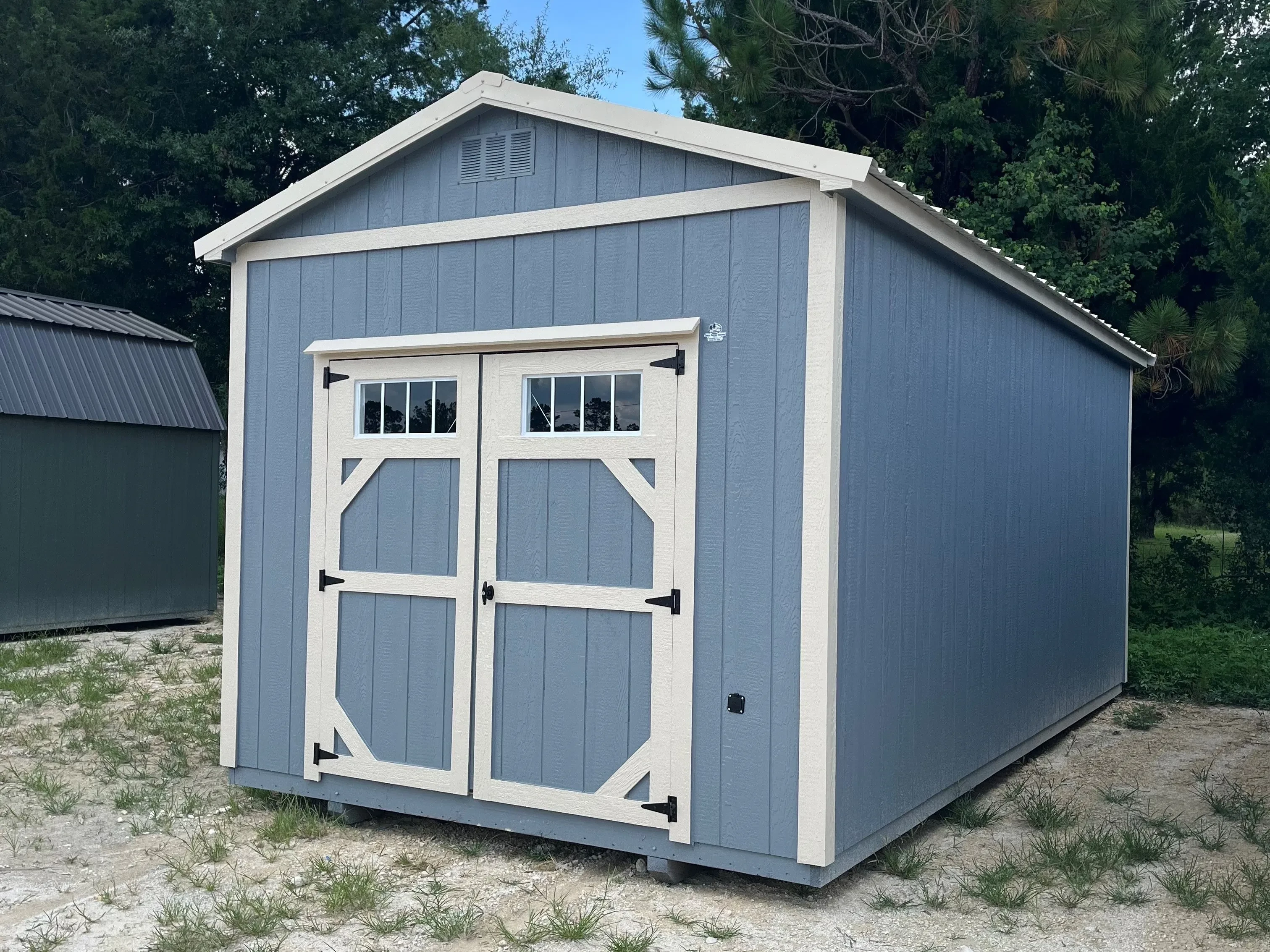 Exterior of a 10x20 garden shed with a double wood door with transoms