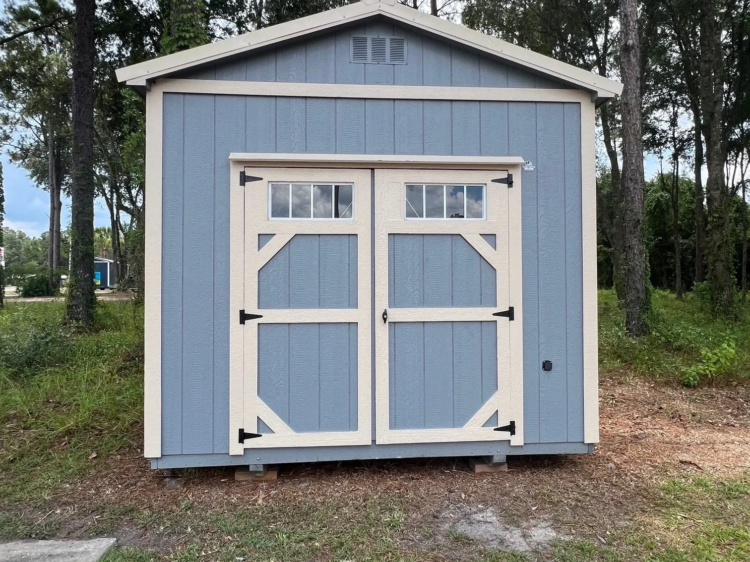 Exterior of a 10x20 grey garden shed double wood doors with transom