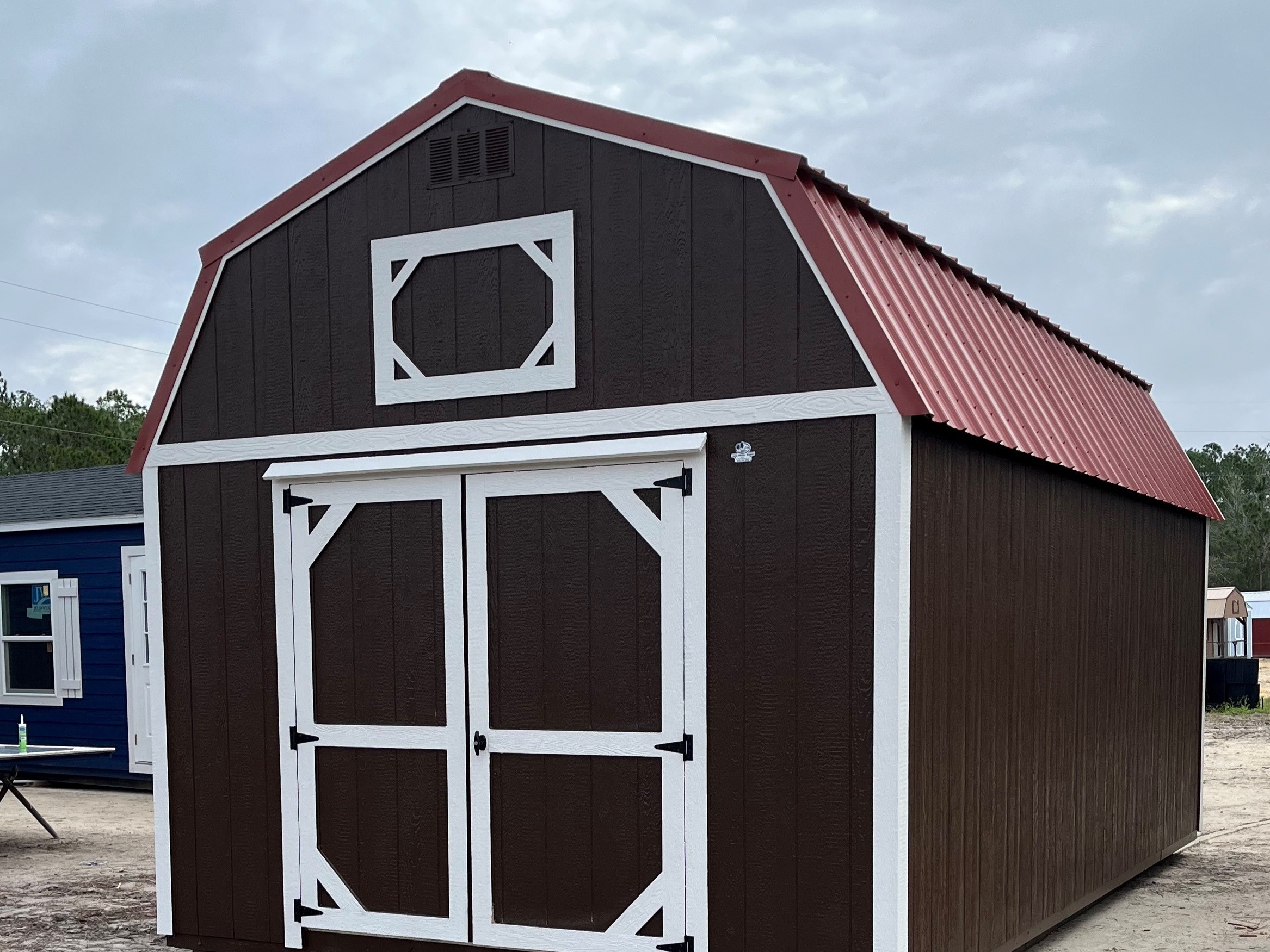 Exterior of a brown 12x20 lofted barn with double wood doors