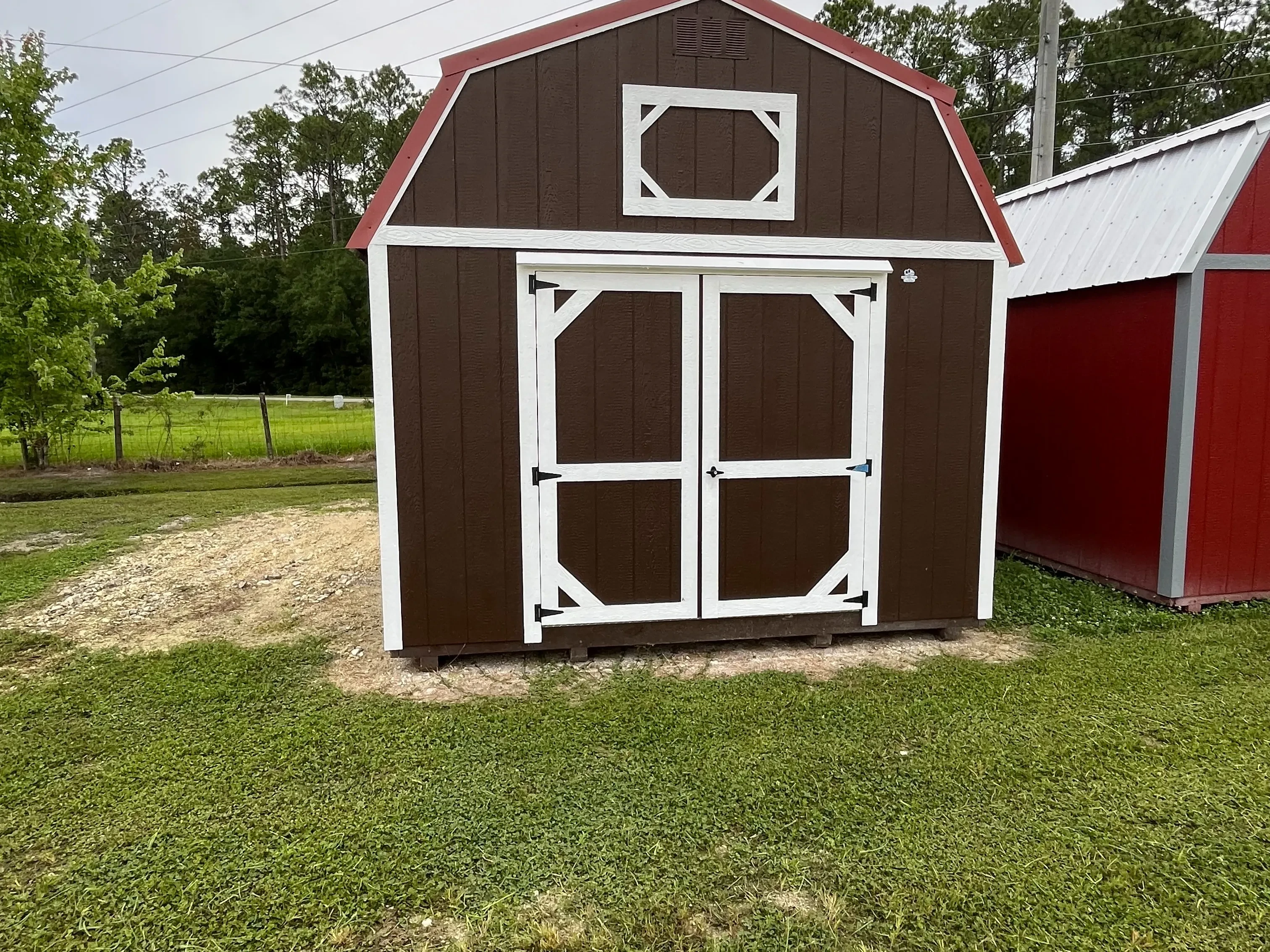Exterior front of a brown 12x20 lofted barn with double wood doors
