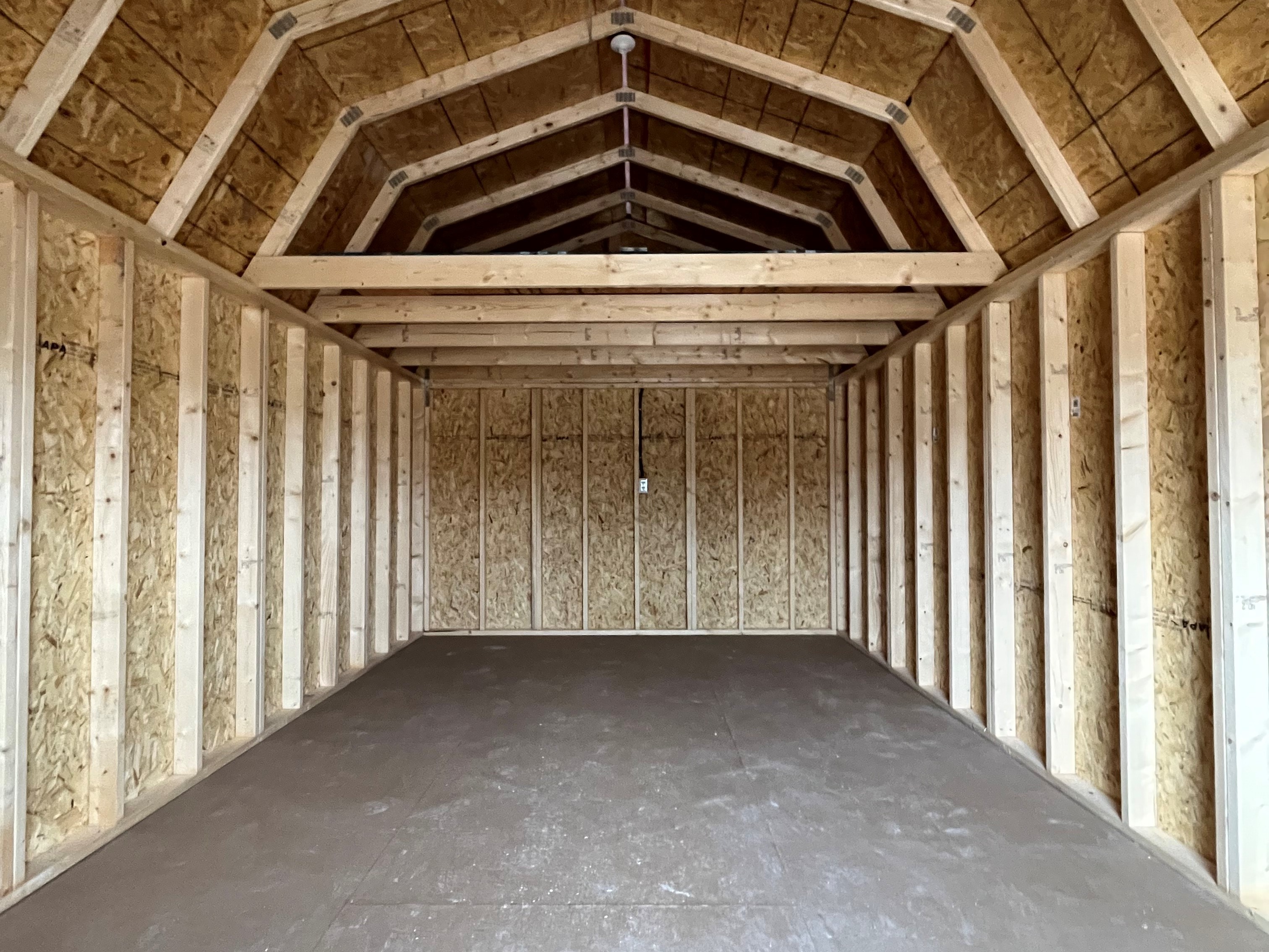 Interior of a 12x20 lofted barn showing through the doors looking at the rear loft space