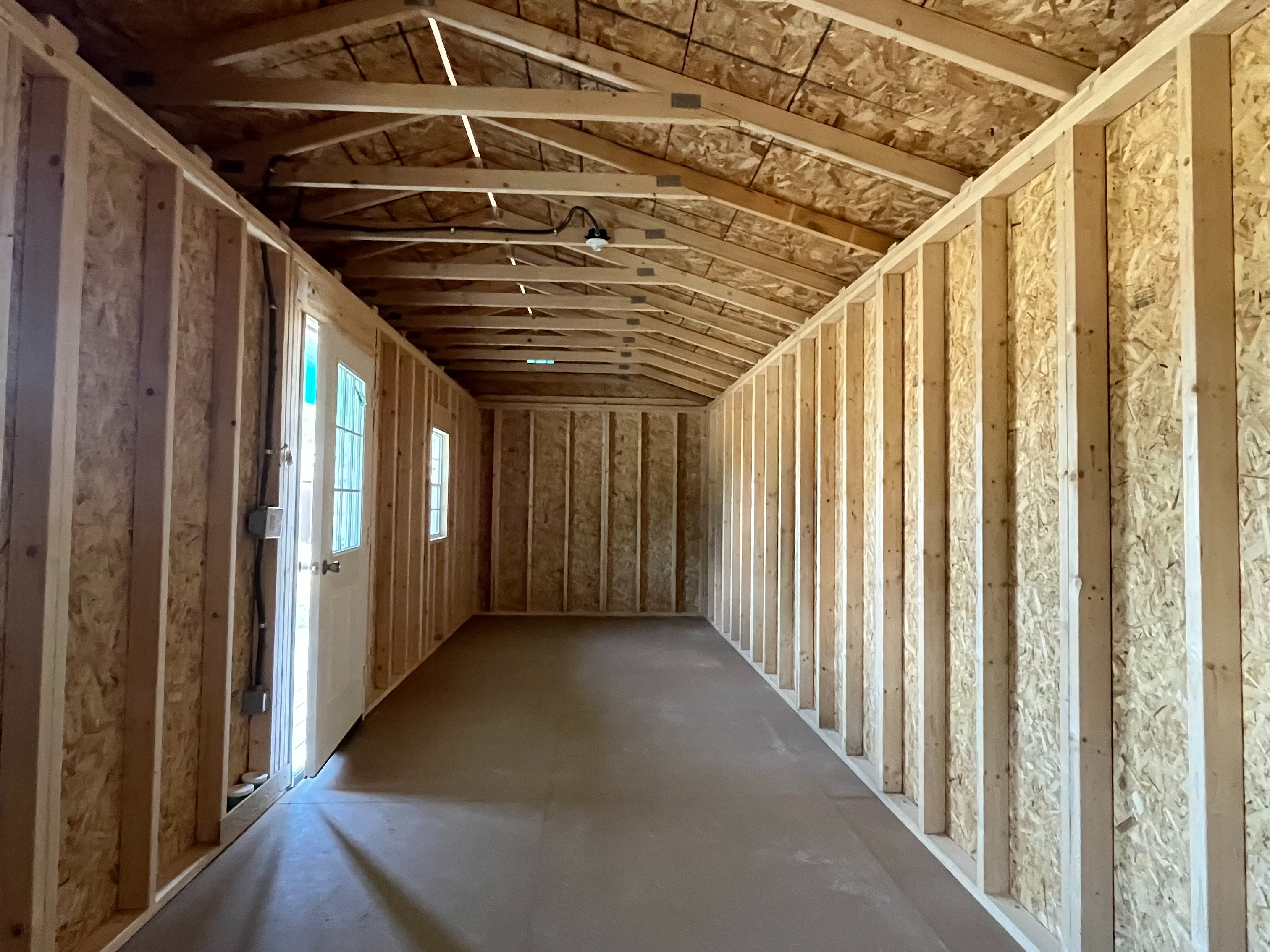 Interior of a 14x28 side porch cabin showing the window and walk-in door