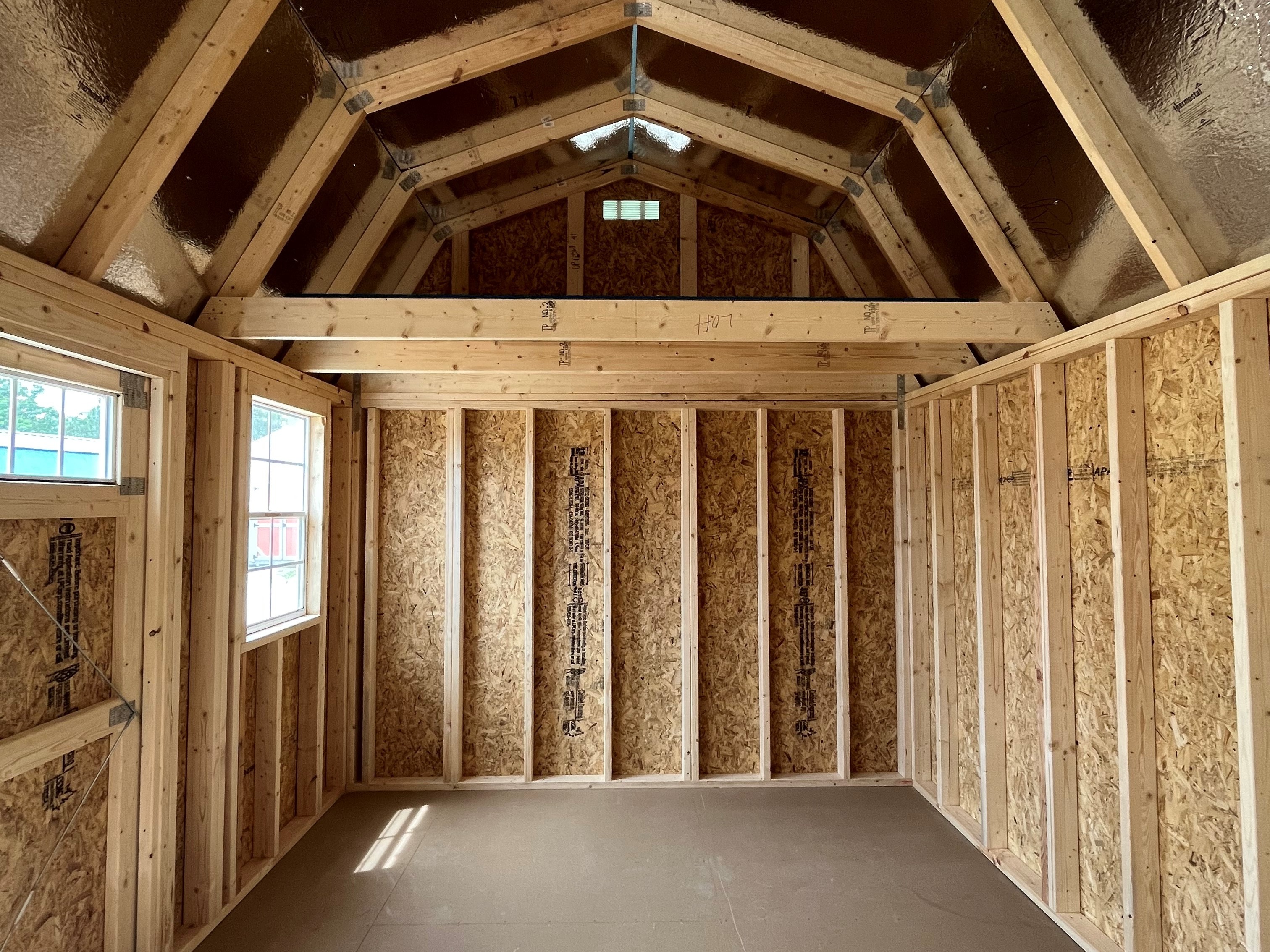 Interior on a 10x16 side lofted barn showing a window and loft space on the left