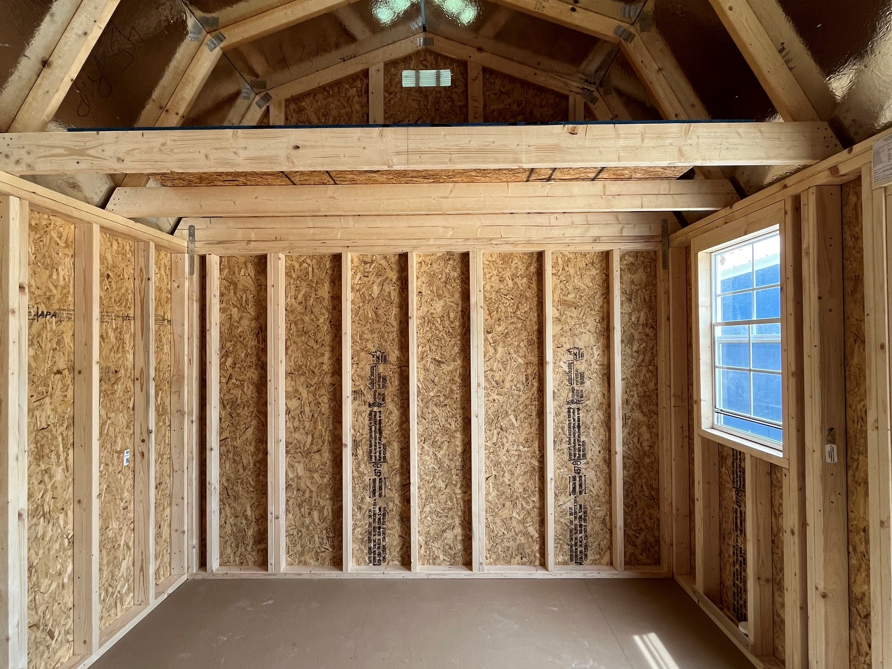 Interior on a 10x16 side lofted barn showing a window and loft space on the right