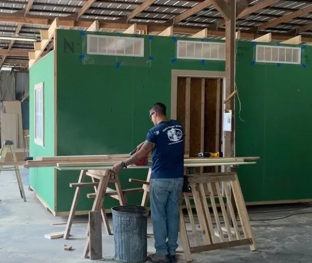 Builder cutting some wood in building a custom shed.
