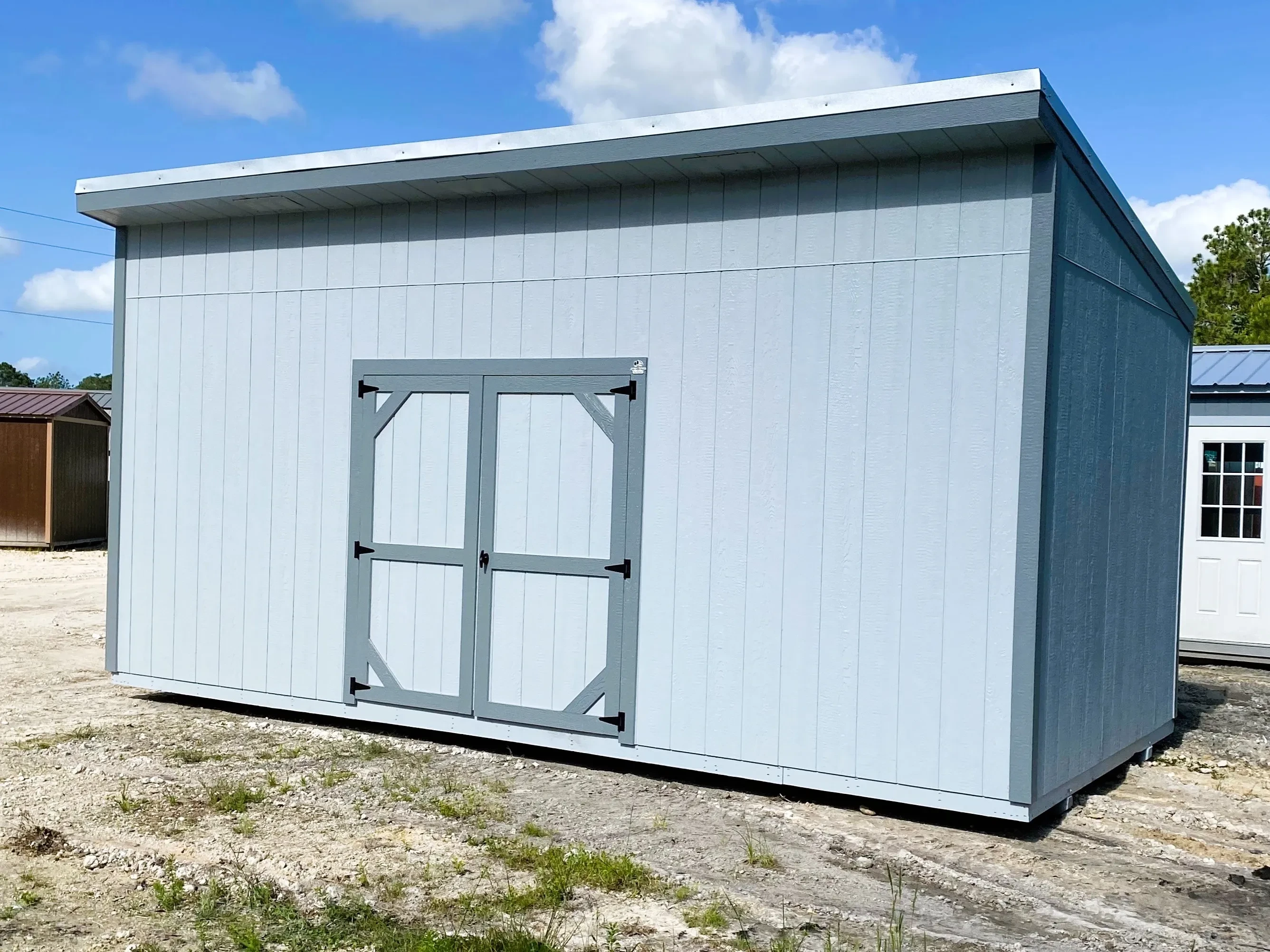 Exterior of a grey 10x20 urban shed with a double wood door