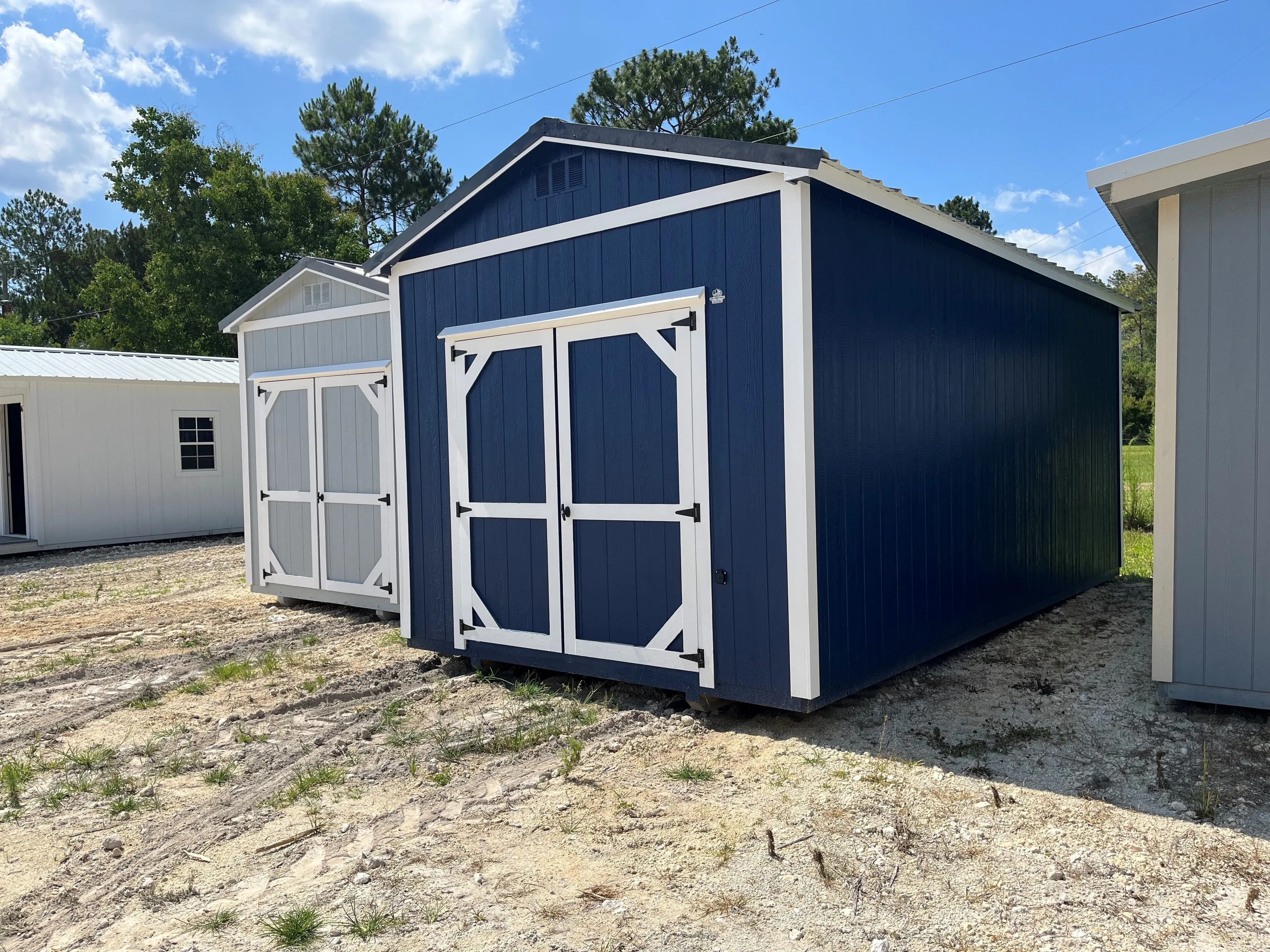Exterior of a dark blue 10x20 garden shed with double wood doors
