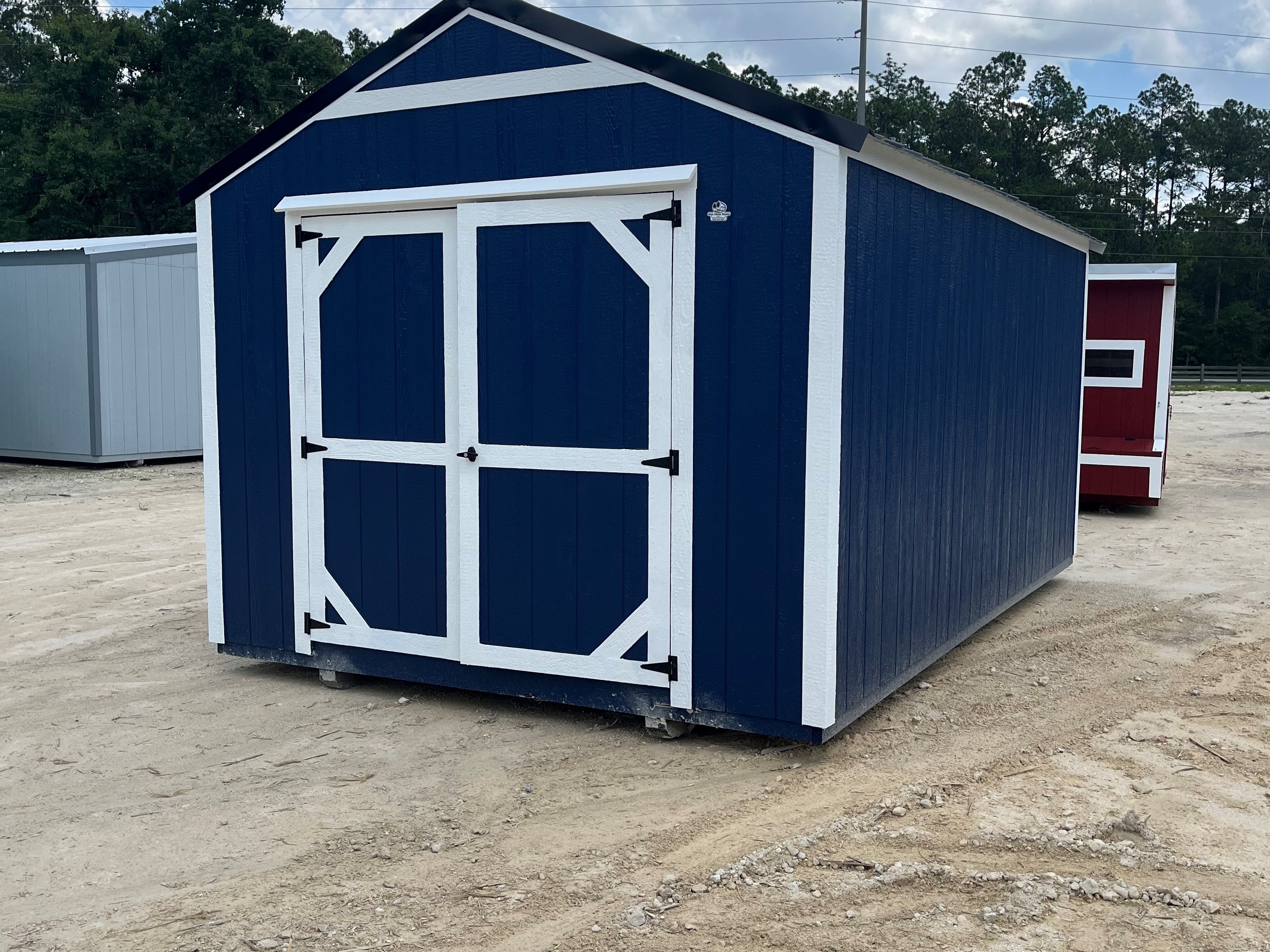 Exterior of a dark blue 10x16 garden shed economy with double wood doors
