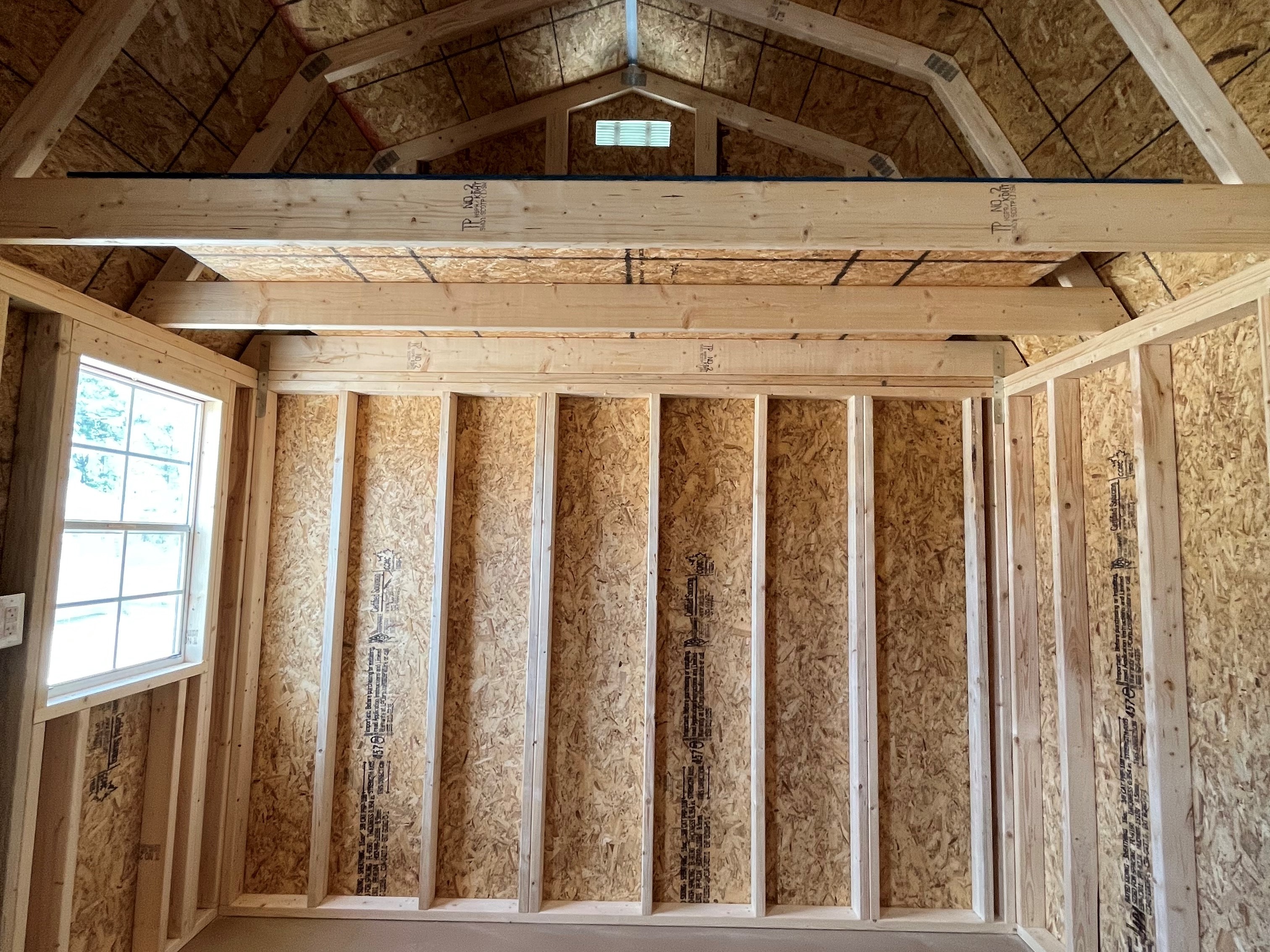 Interior of a 10x12 side lofted barn showing a loft and window