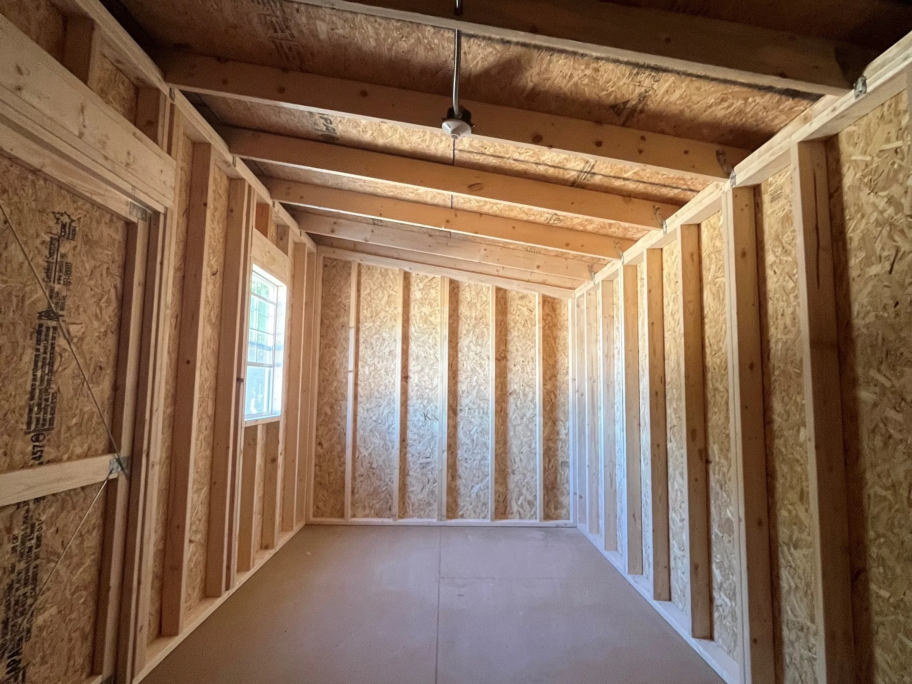 Interior of an 8x16 urban shed showing the inside of the double doors and a window