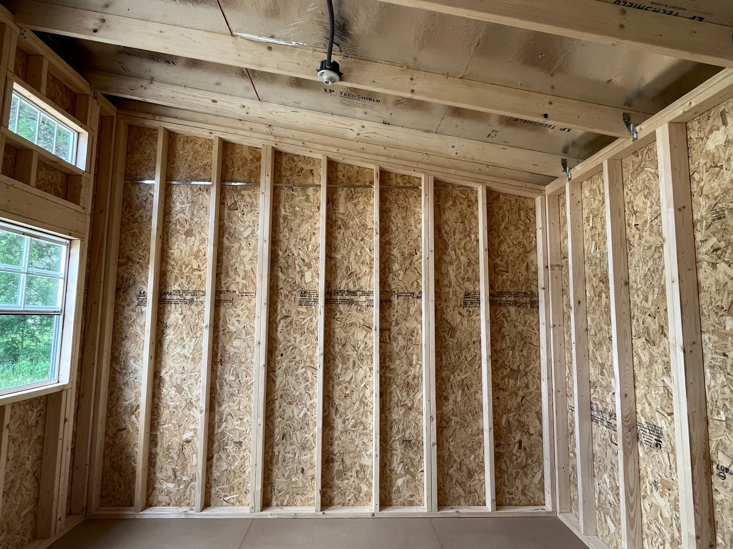 Interior of a 12x12 urban shed showing a window and a transom window