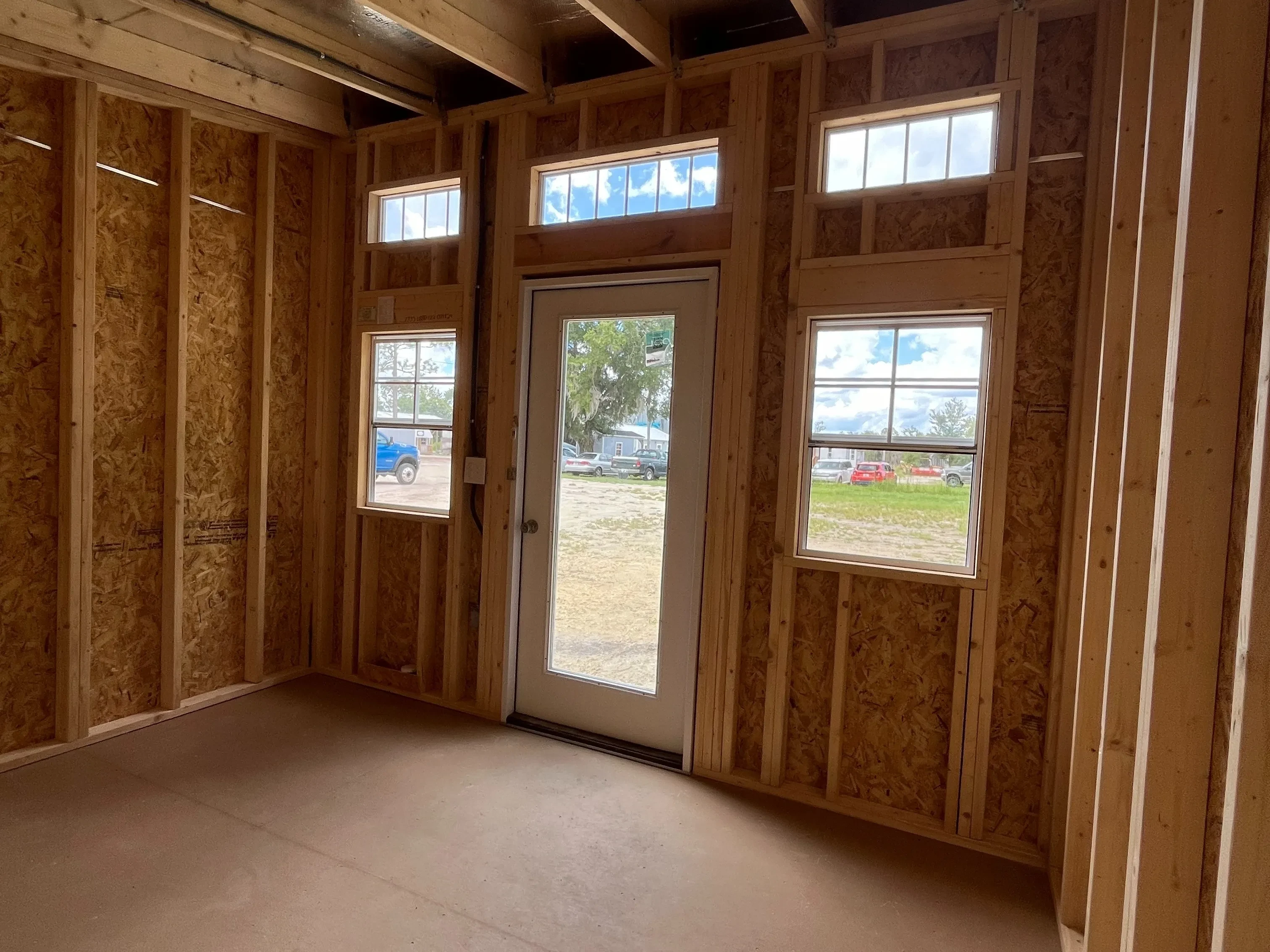 Interior of a 12x12 urban shed showing the entry door and many windows