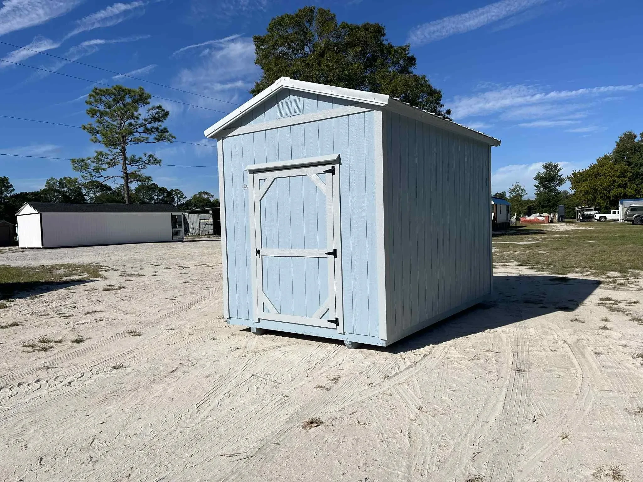 Exterior of a light blue 8x12 garden shed with a single wood door