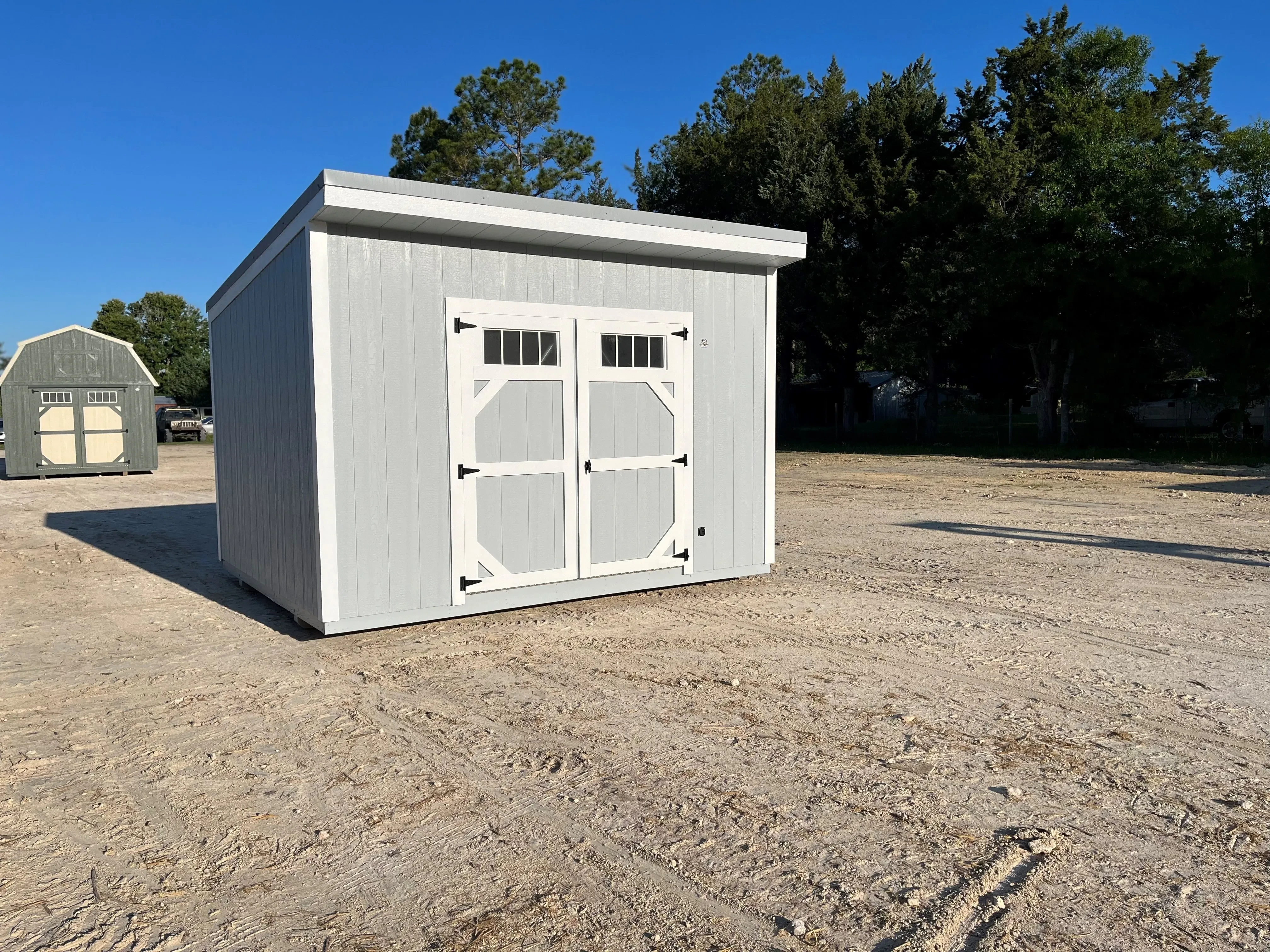 Exterior of a light grey 10x12 urban with double wood doors and transom window
