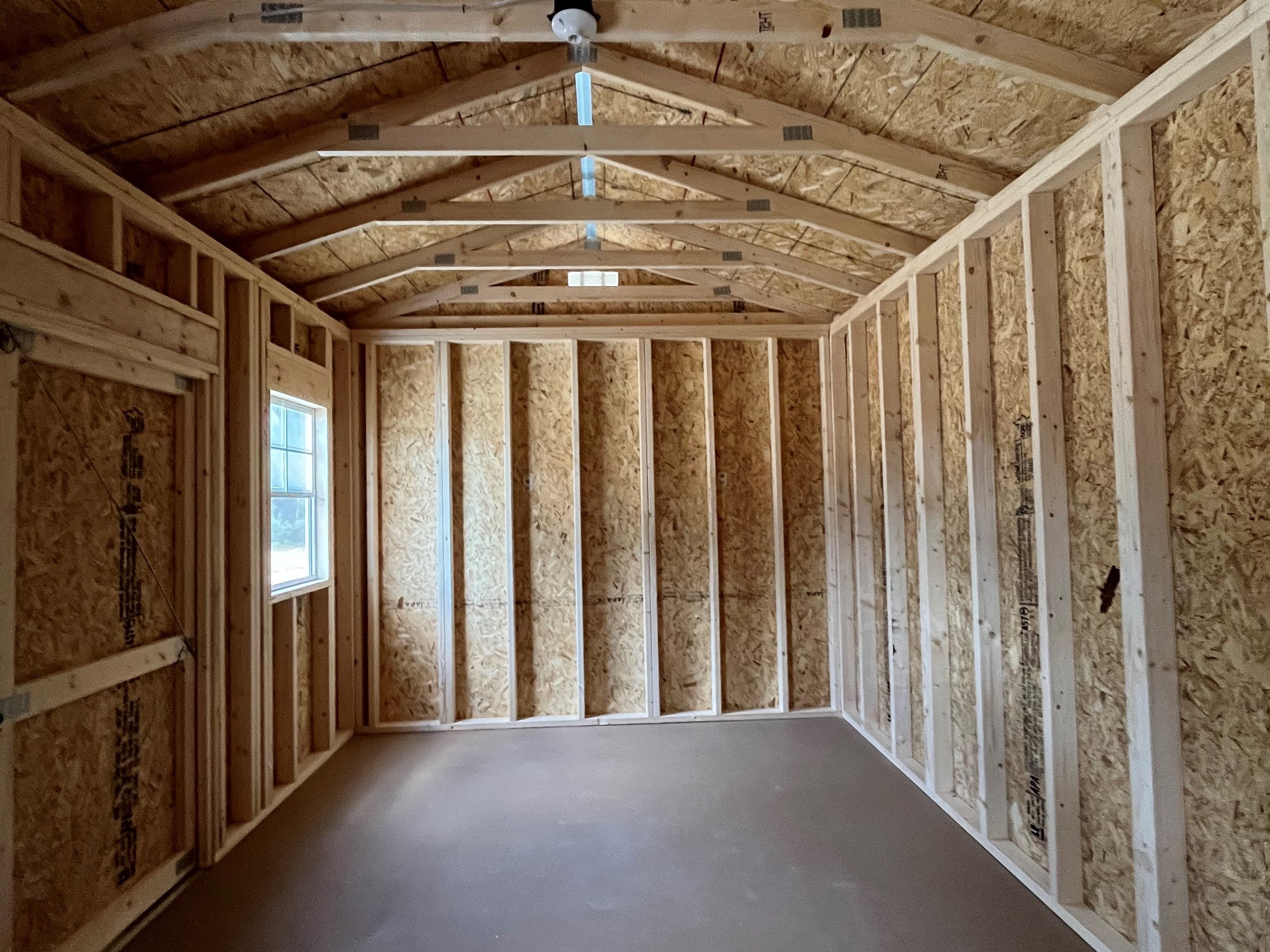 Interior of a 10x16 side garden shed showing the inside of the double doors and a window
