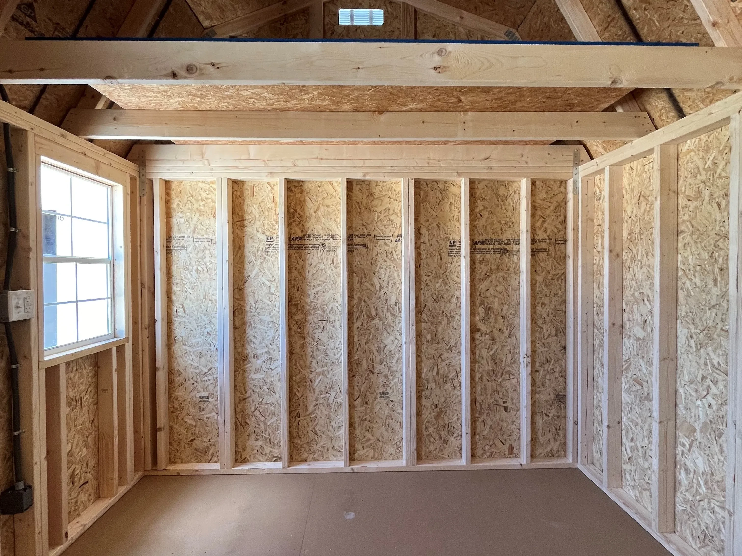 Interior left side of a 10x12 side lofted barn showing the loft and window