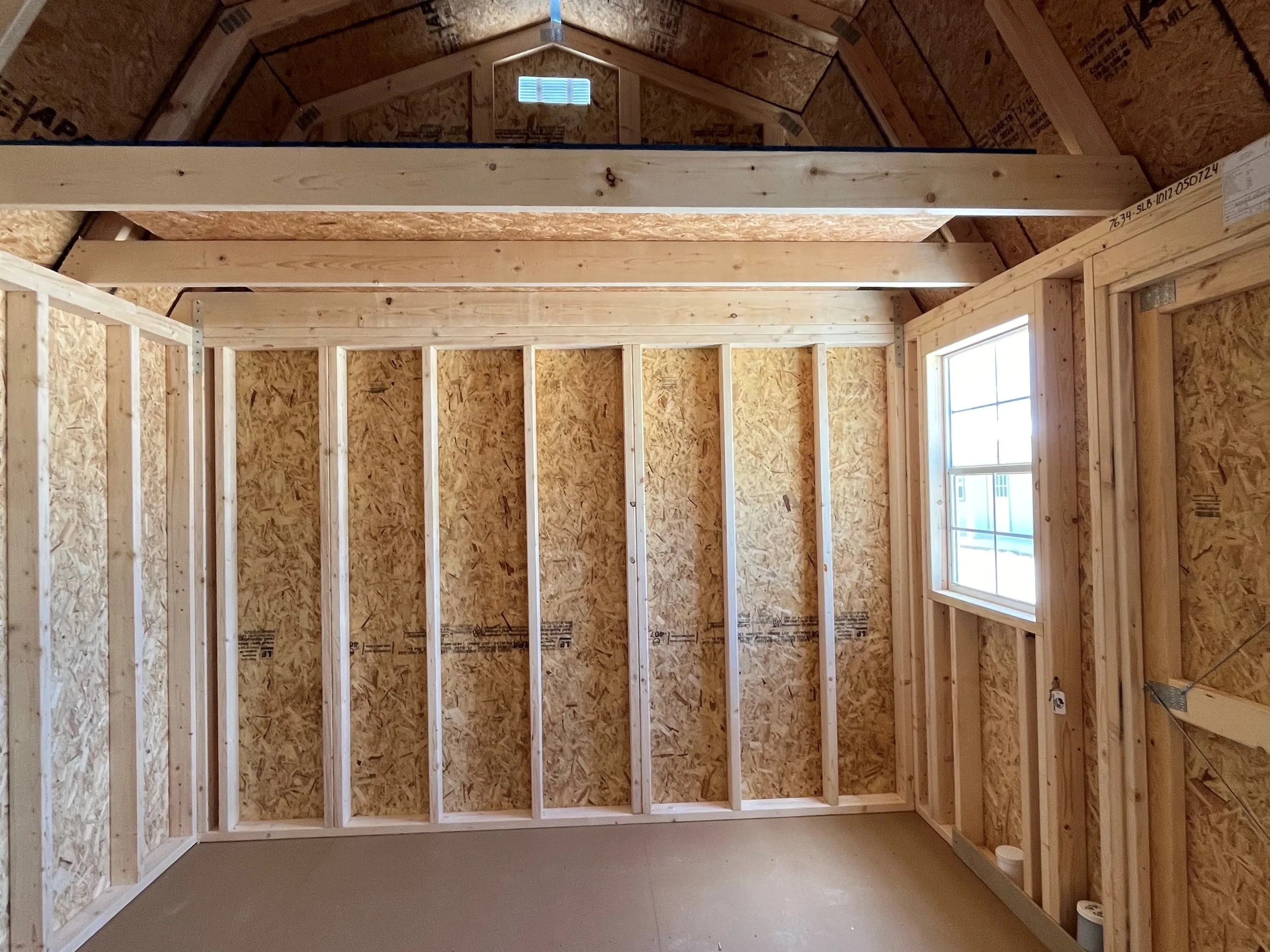 Interior right side of a 10x12 side lofted barn showing the loft and window