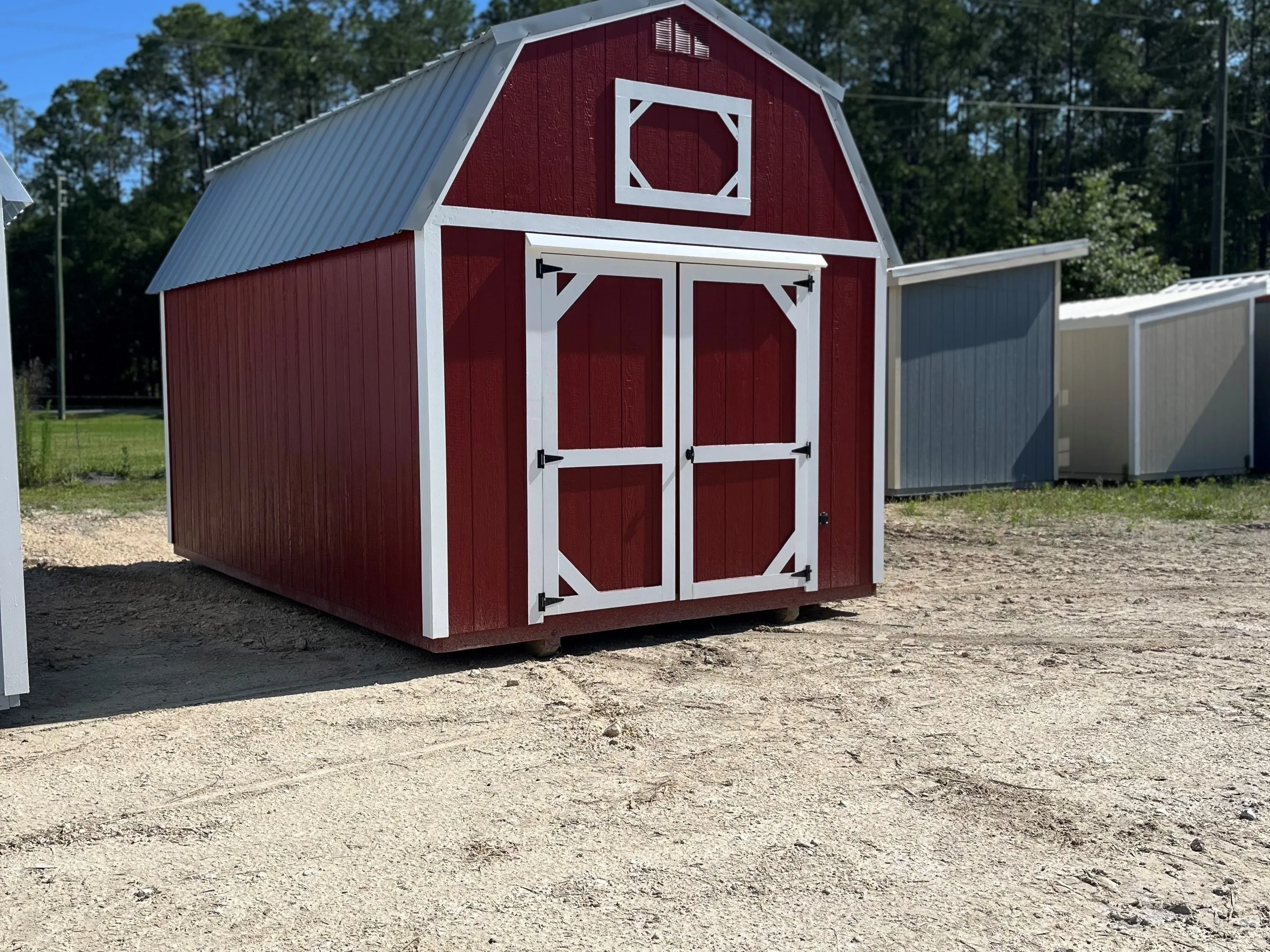 Exterior of a red 10x16 lofted barn with double wood doors