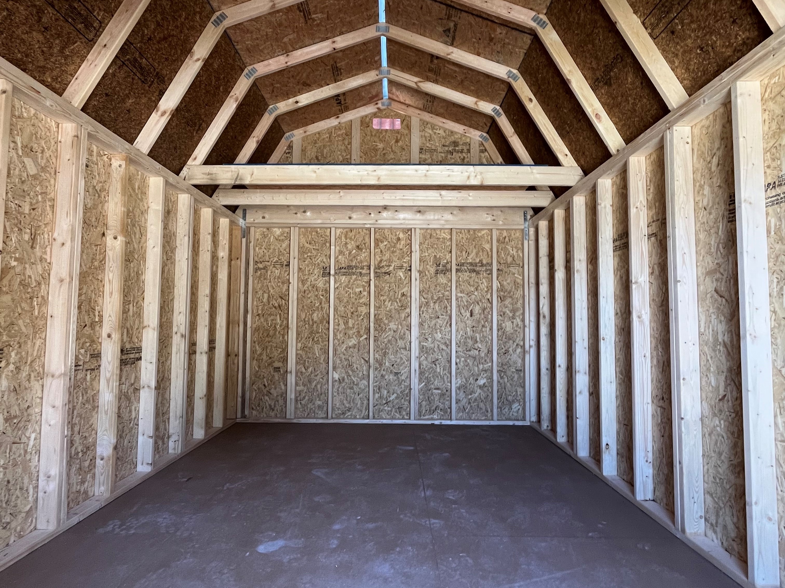 Interior of a 10x16 lofted barn viewing through the doors showing the loft