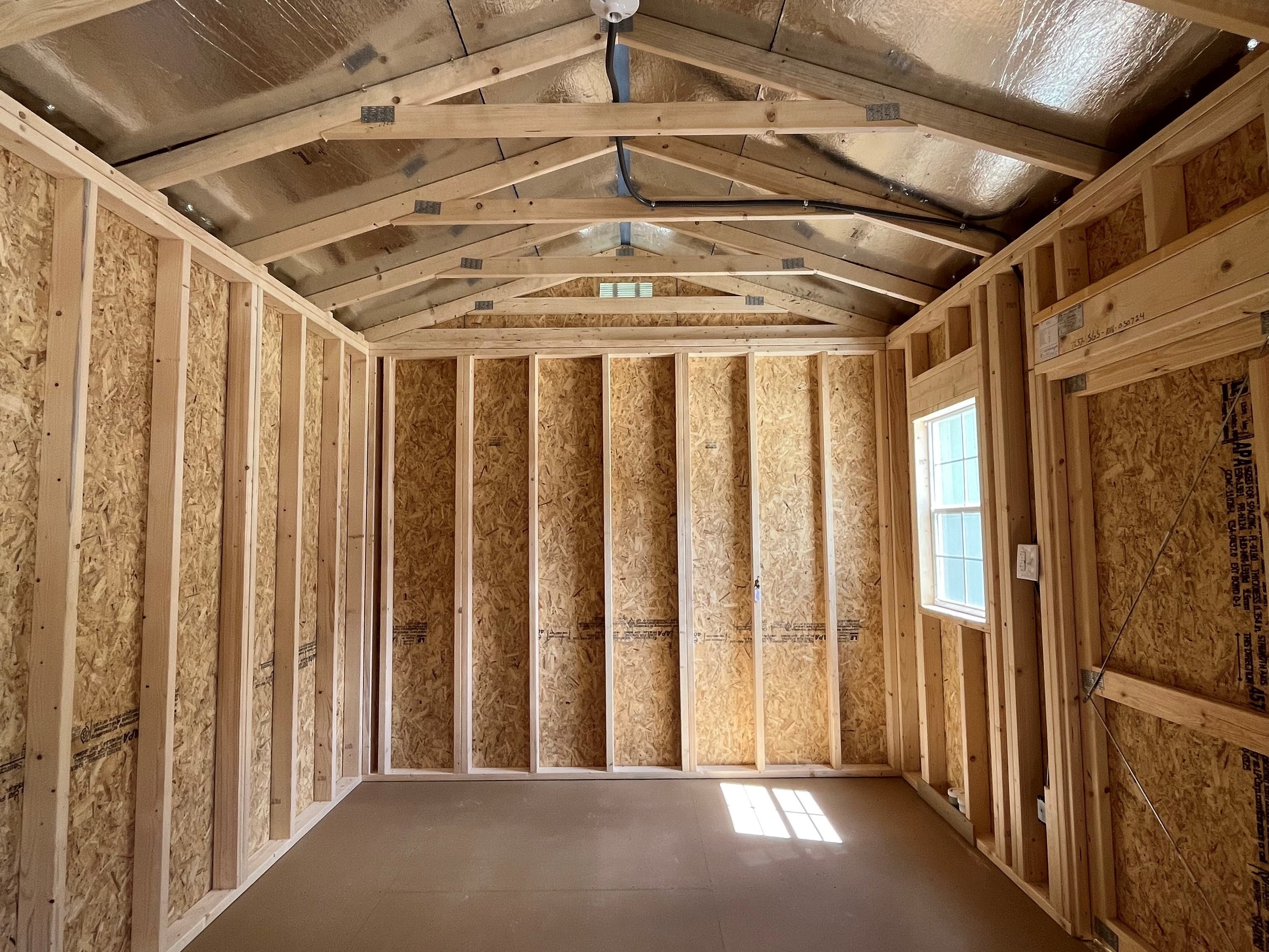 Interior right side of a 10x16 side garden shed showing the window and radiant barrier