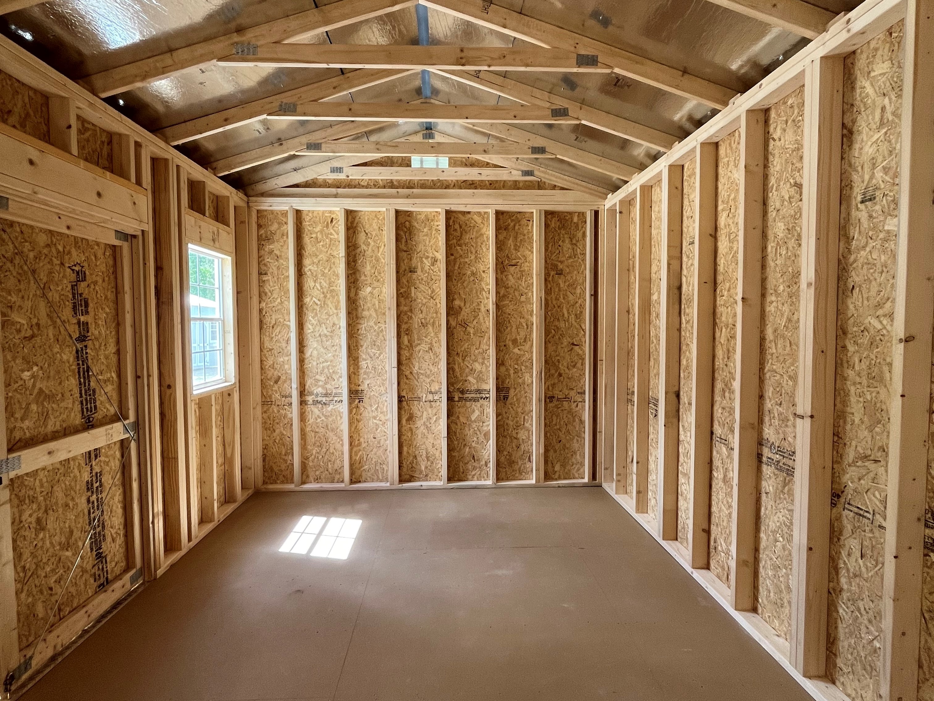 Interior left side of a 10x16 side garden shed showing the window and radiant barrier