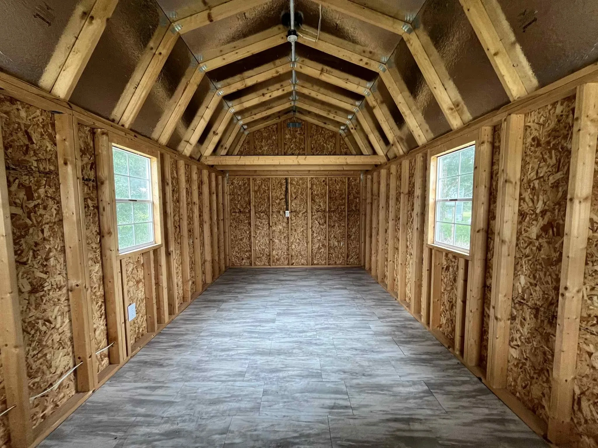 Interior view of a 10x24 lofted barn cabin showing the loft, radiant barrier and windows