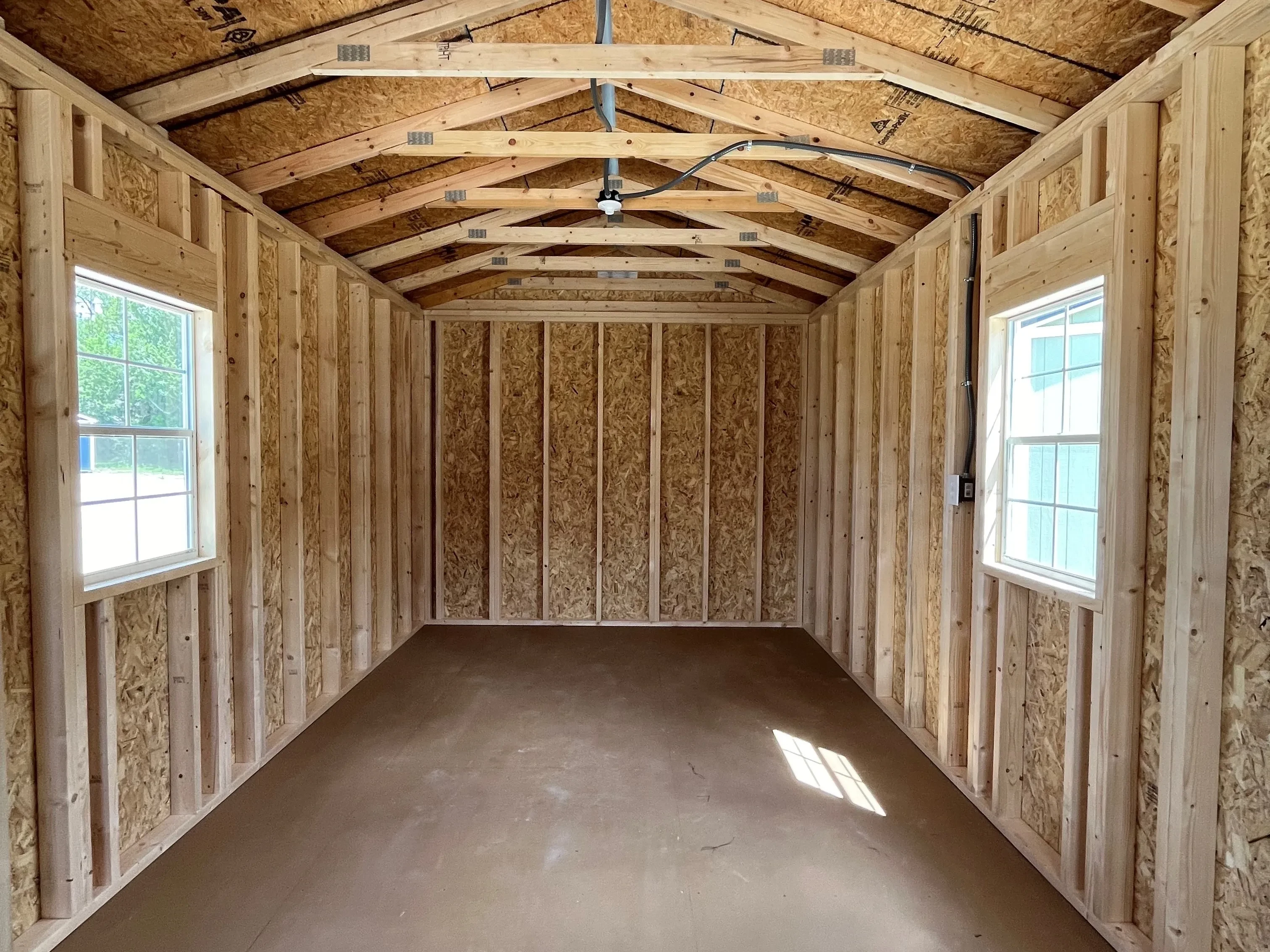 Inside of a 10x24 cabin showing two windows and electric
