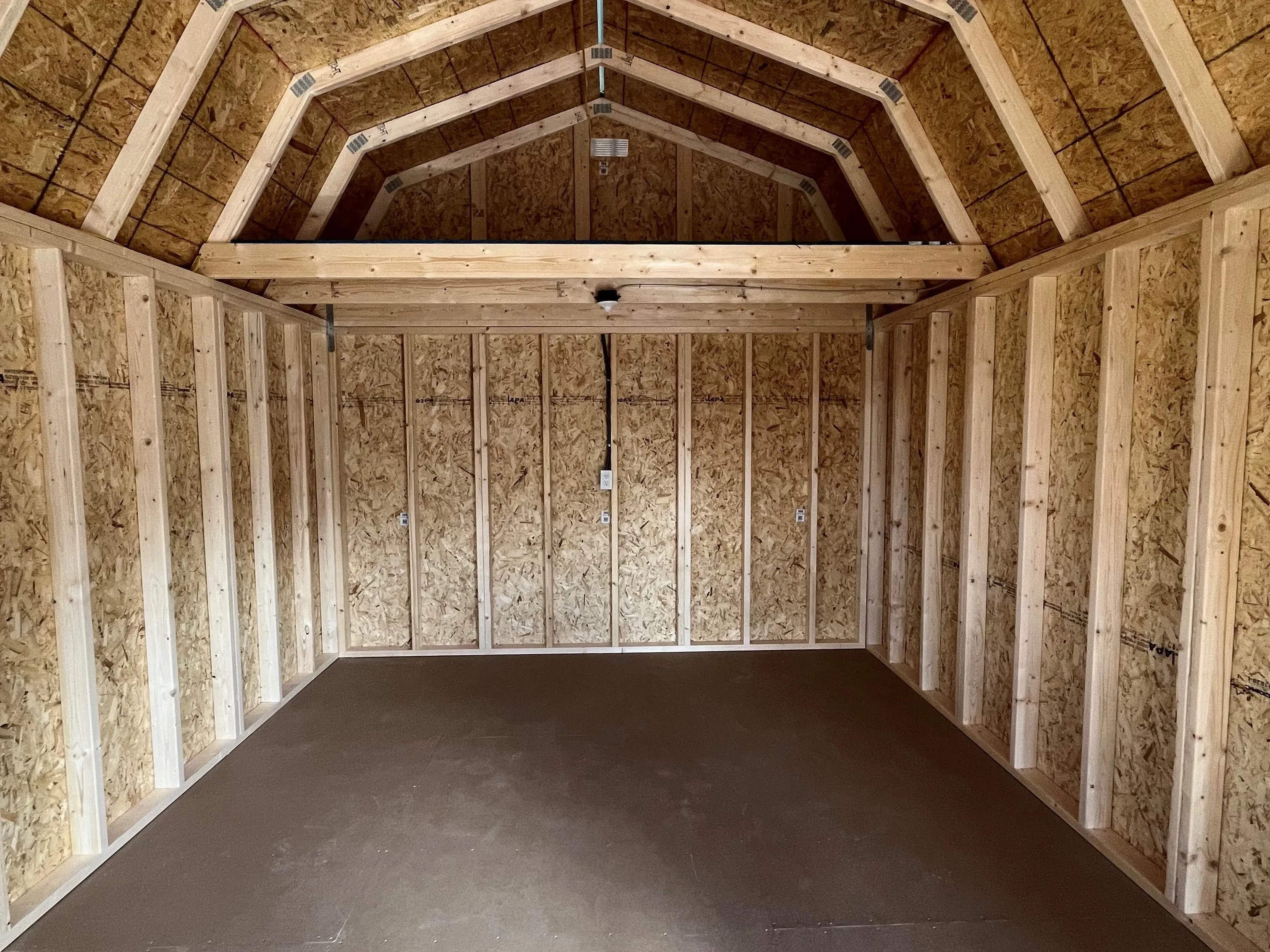 Inside of 12x24 lofted corner porch cabin showing a large loft and electric