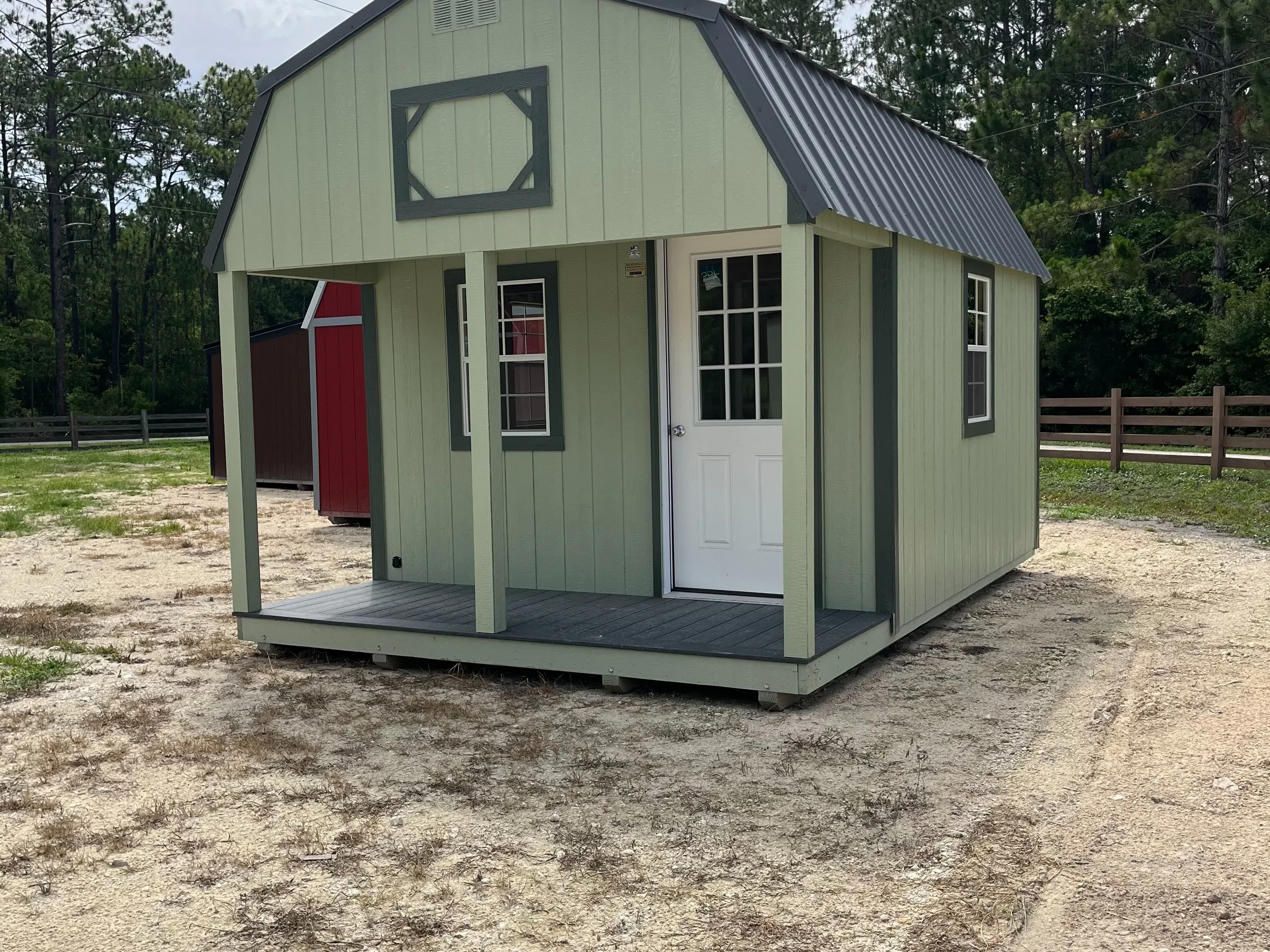 Exterior of a 12x16 Lofted Barn Barn showing the porch, walk-in door and windows