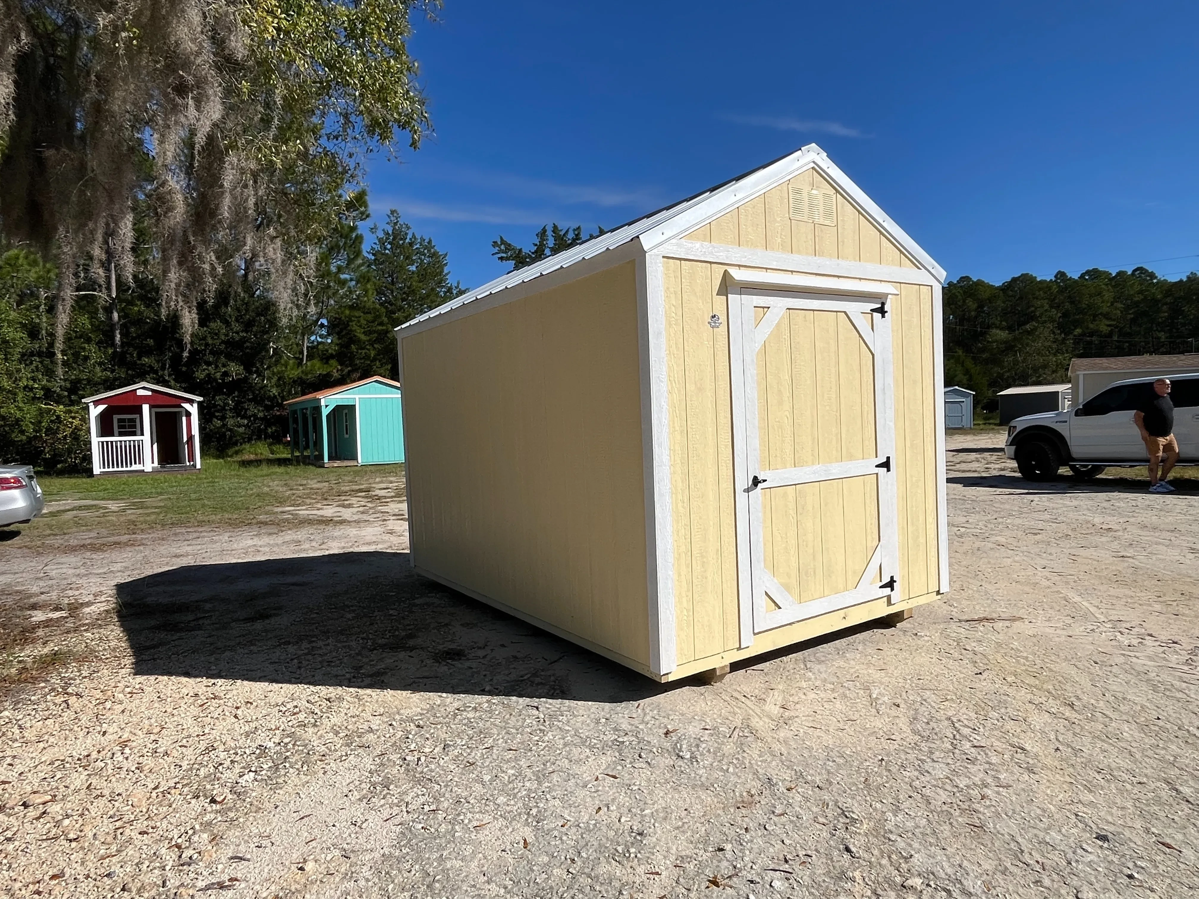 Exterior photo of a yellow with white trim 8x12 Garden Shed Economy showing left side and front