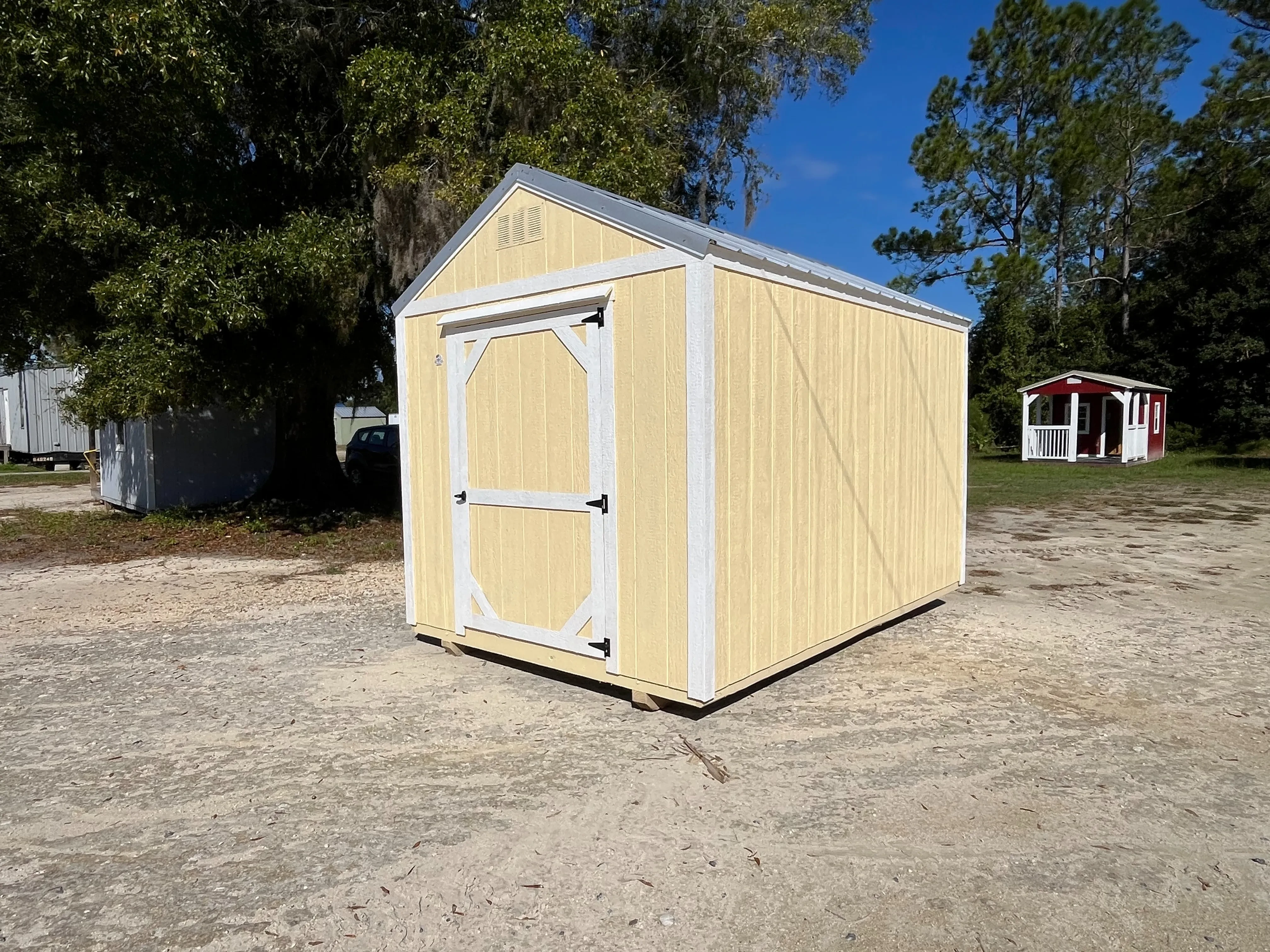 Exterior photo of a yellow with white trim 8x12 Garden Shed Economy showing right side and front