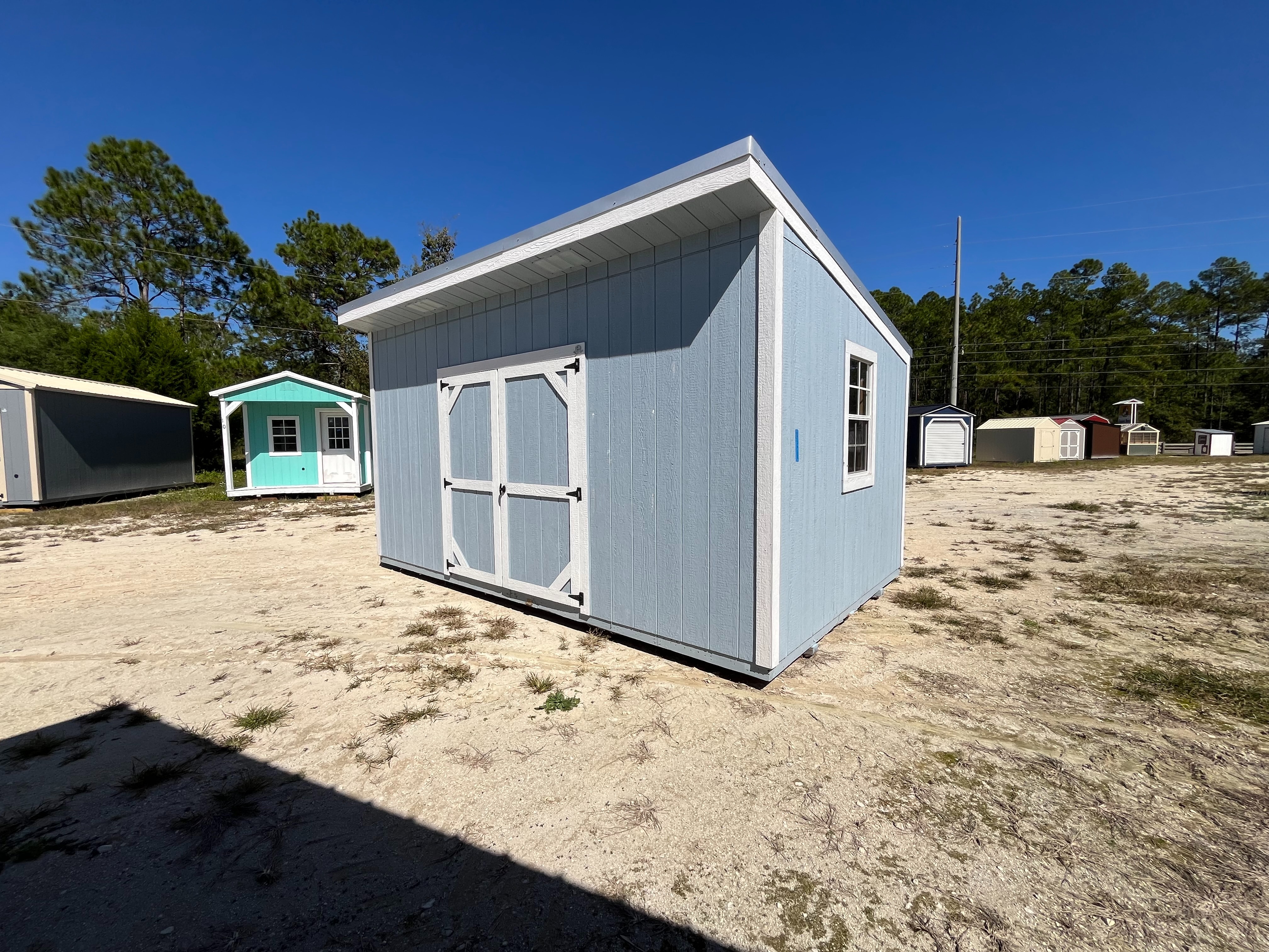 Exterior right side of a 10x16 urban shed that has a double wood door and a window