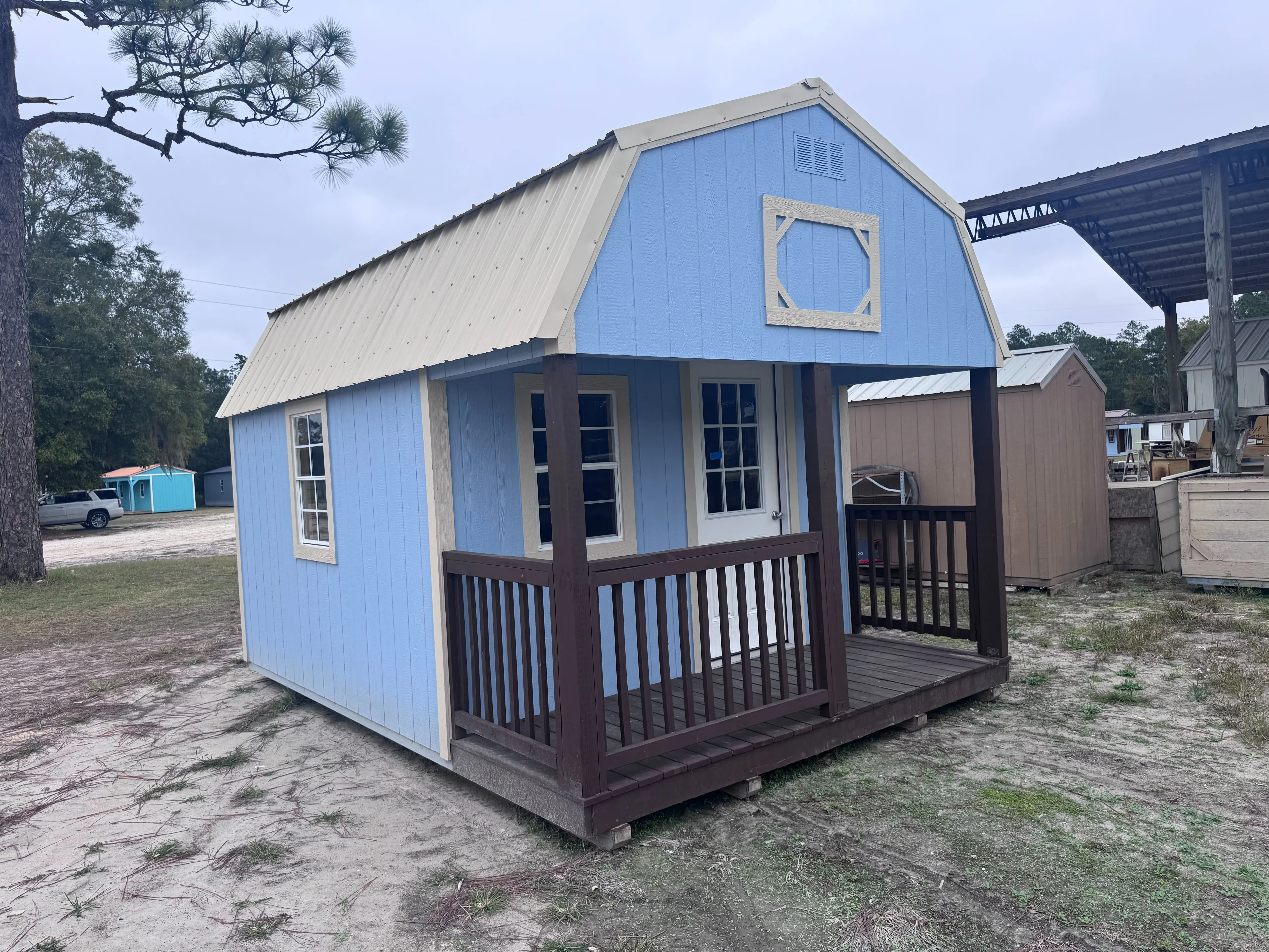 Side view of 12x16 Lofted Barn Cabin showing windows and brown porch railing