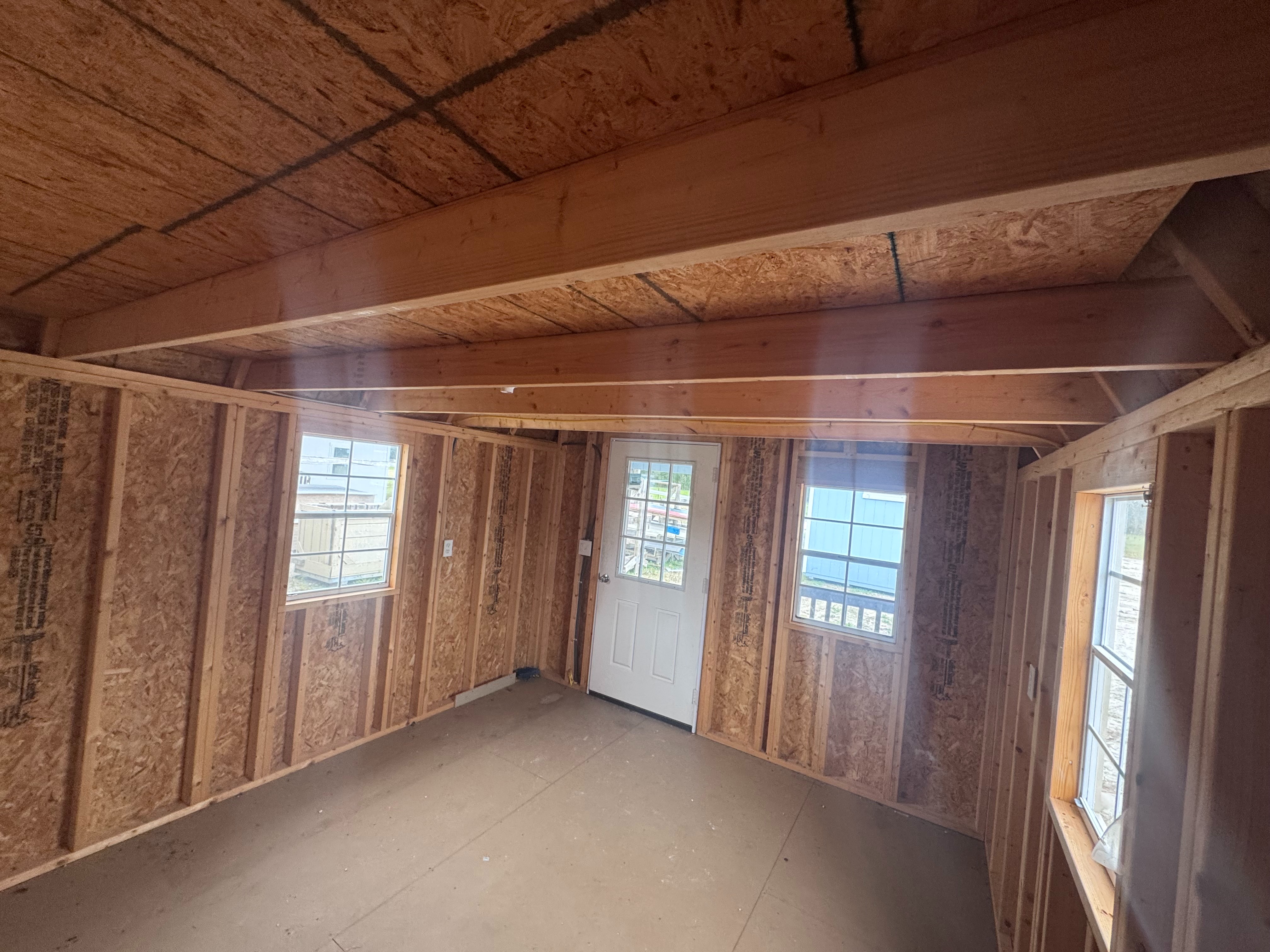 Interior of 12x16 Lofted Barn Cabin showing door, windows, and light package