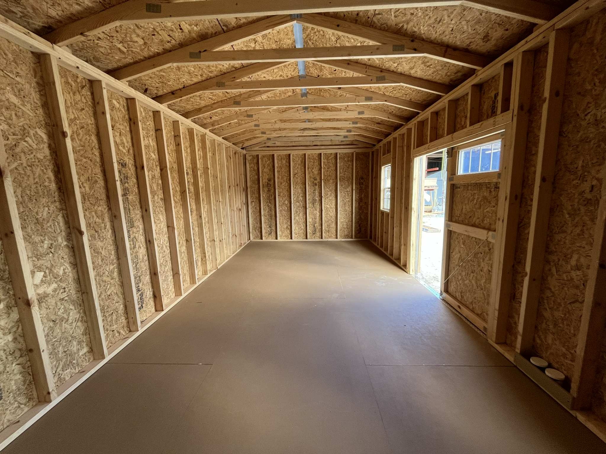 Interior of a 10x20 side garden shed showing windows and double door with transom window