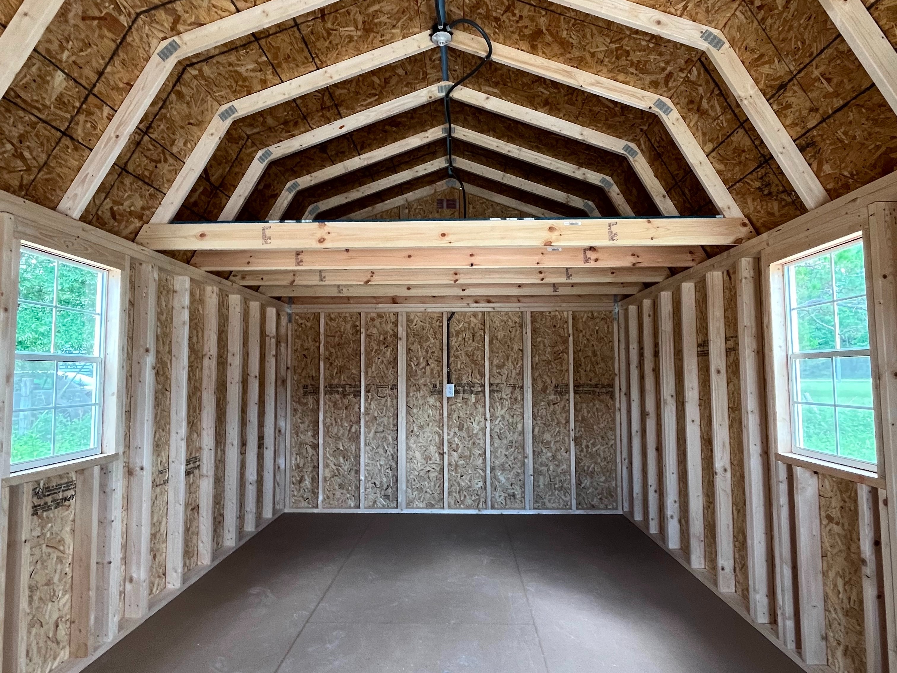 Interior of lofted barn cabin showing two windows and an eight foot loft in the back