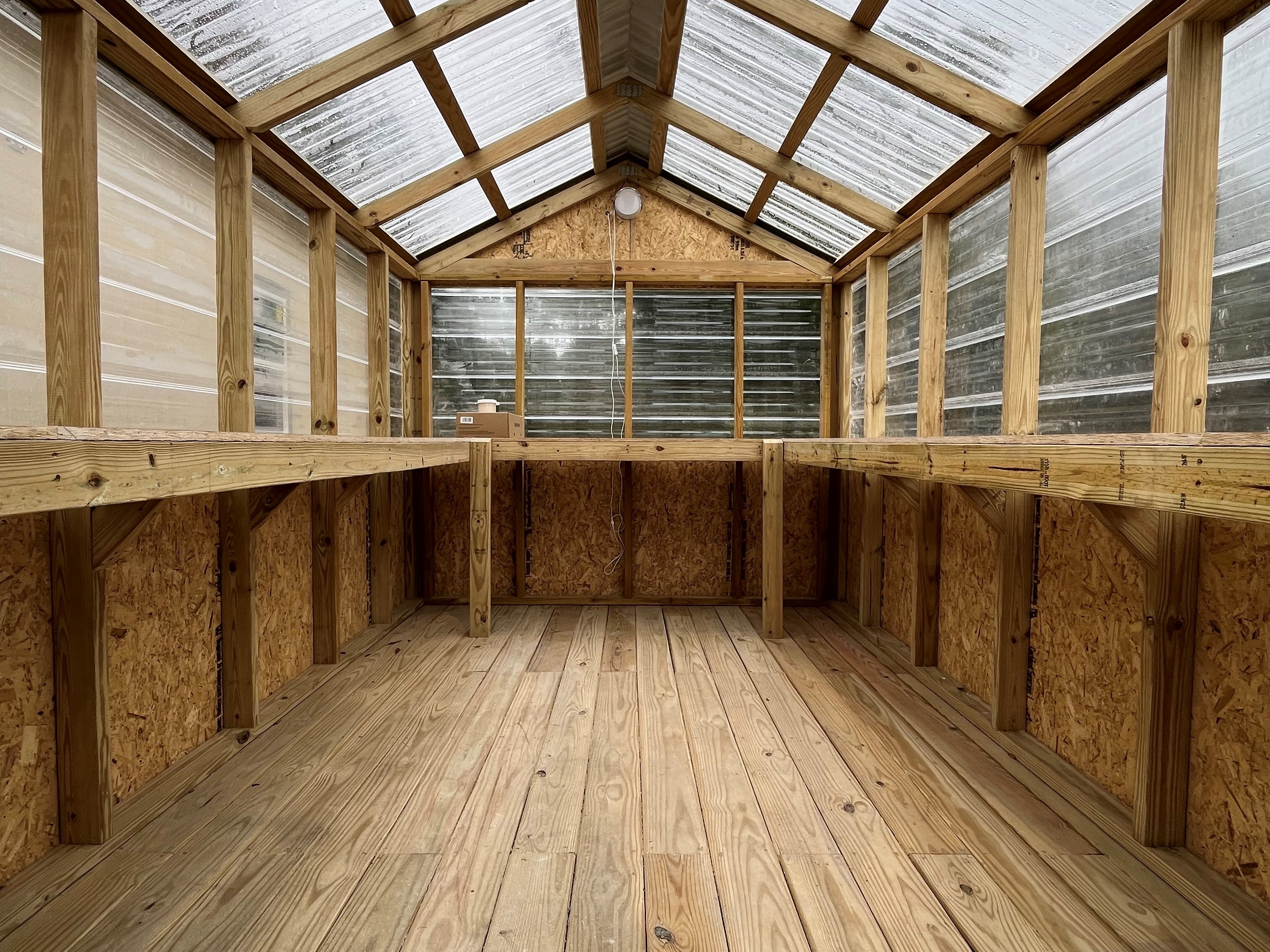 Interior of an 8x12 greenhouse showing the shelfing