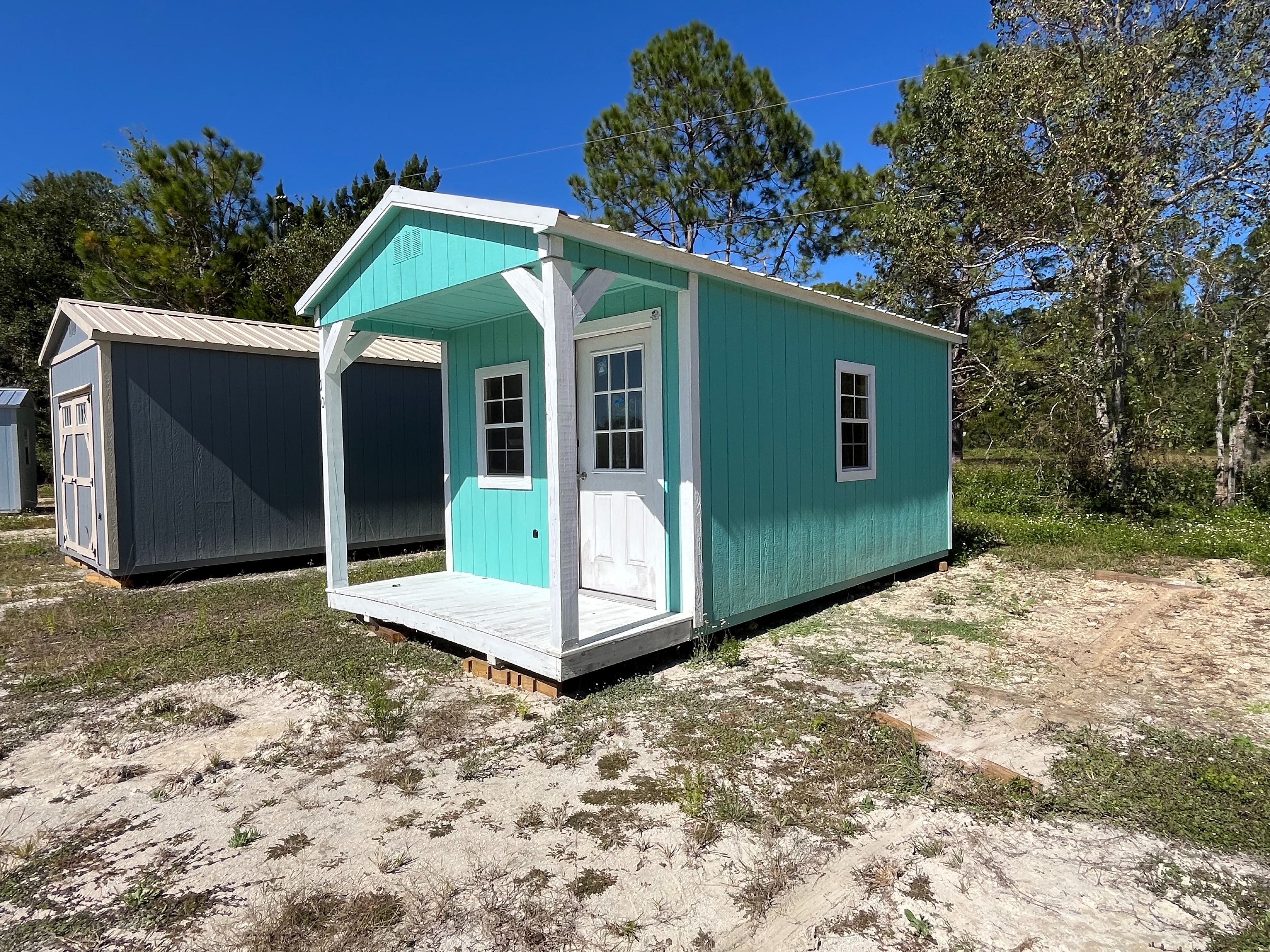 Exterior of a 10x20 Cabin showing the porch,  walk-in door and windows