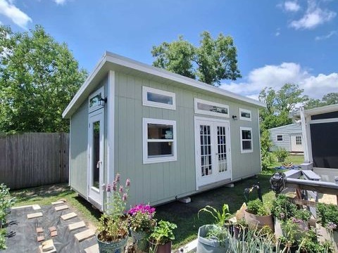 Urban style wood shed with many windows and doors in a backyard