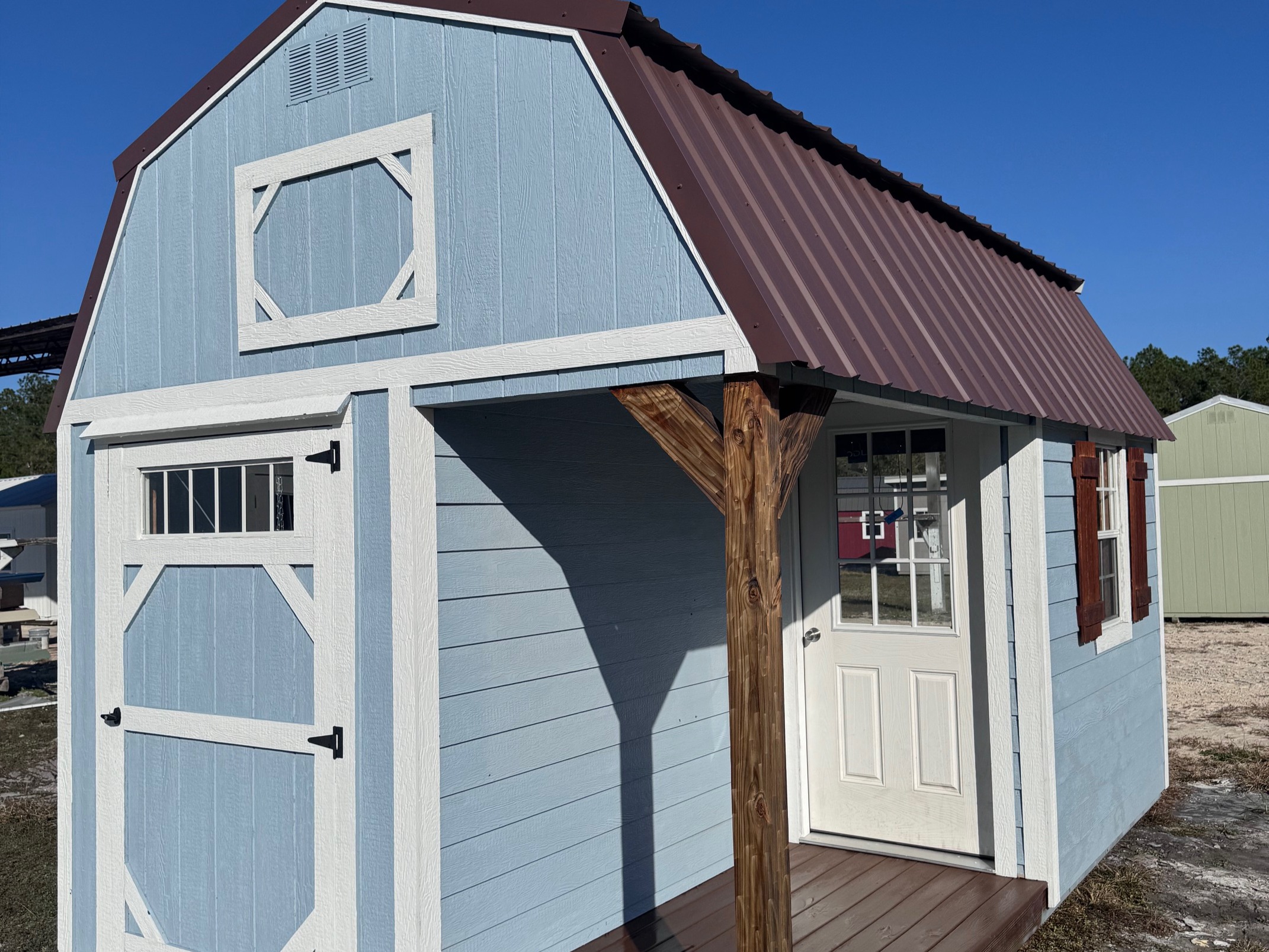 10x16 Lofted Barn Cabin with Dockside Blue siding, white trim, brown roof, porch, and shutters